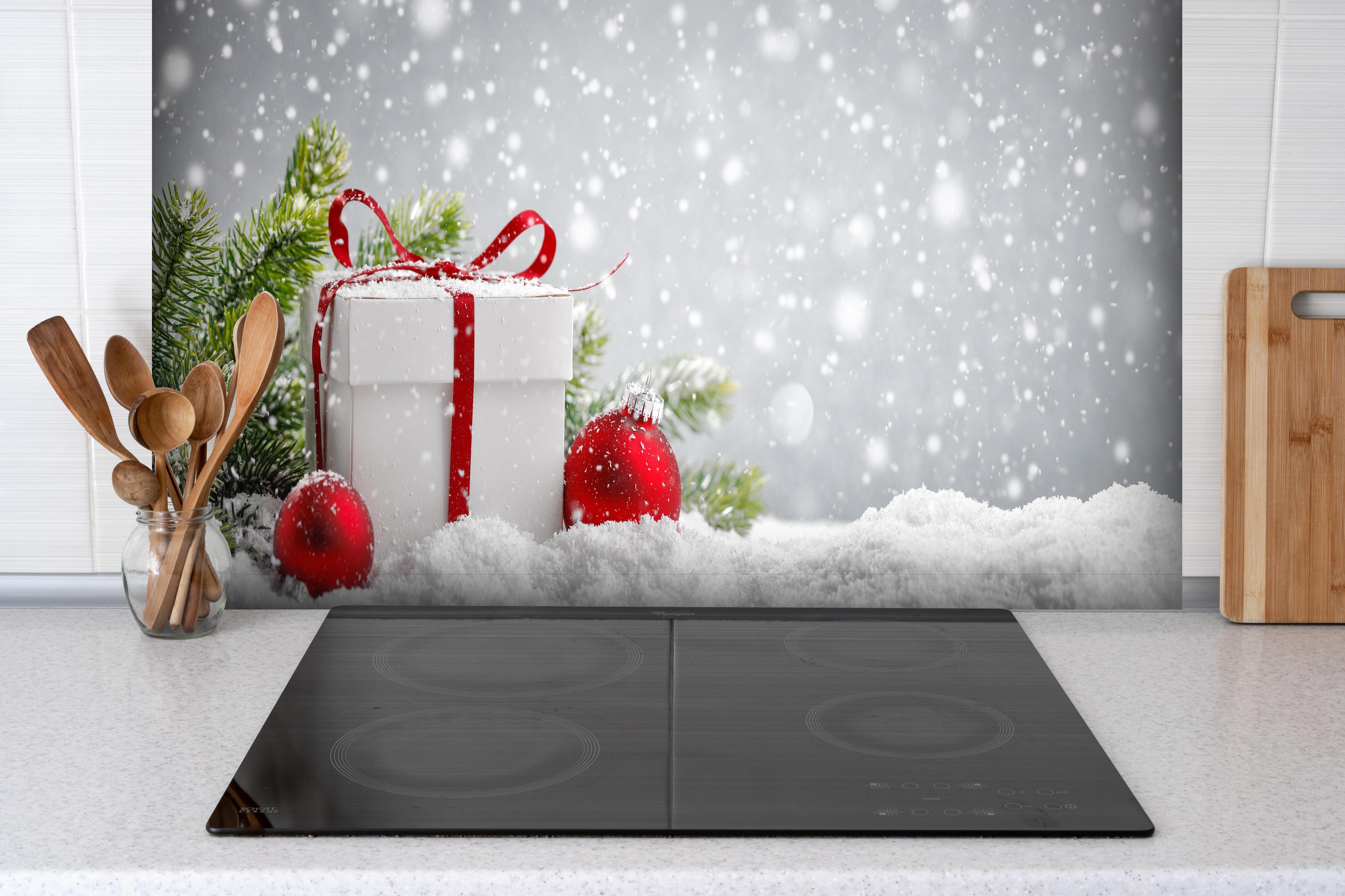 Spritzschutz - Weihnachtsdekoration hinter einem Cerankochfeld zwischen Holz-Kochutensilien