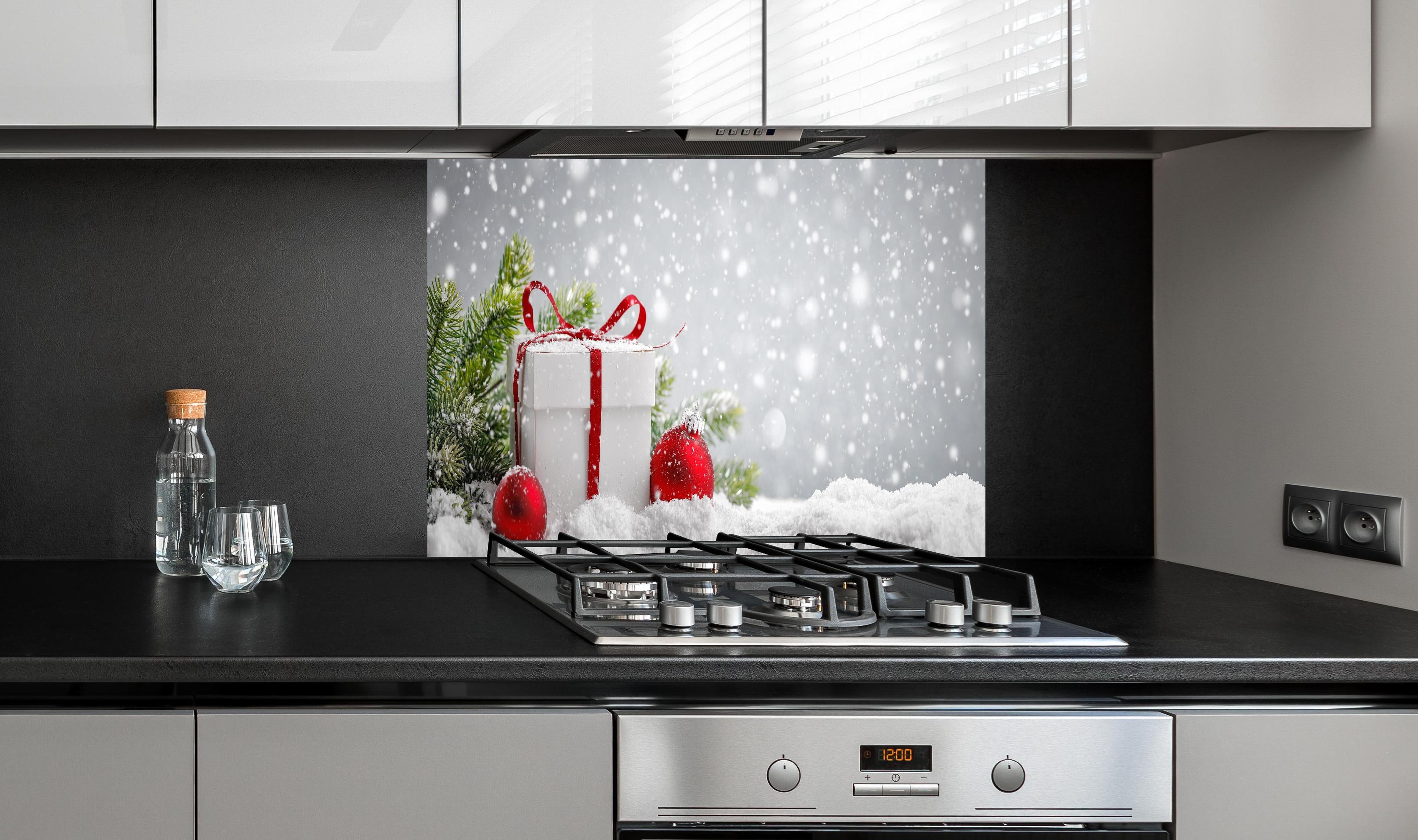 Spritzschutz - Weihnachtsdekoration hinter einem Cerankochfeld zwischen Holz-Kochutensilien