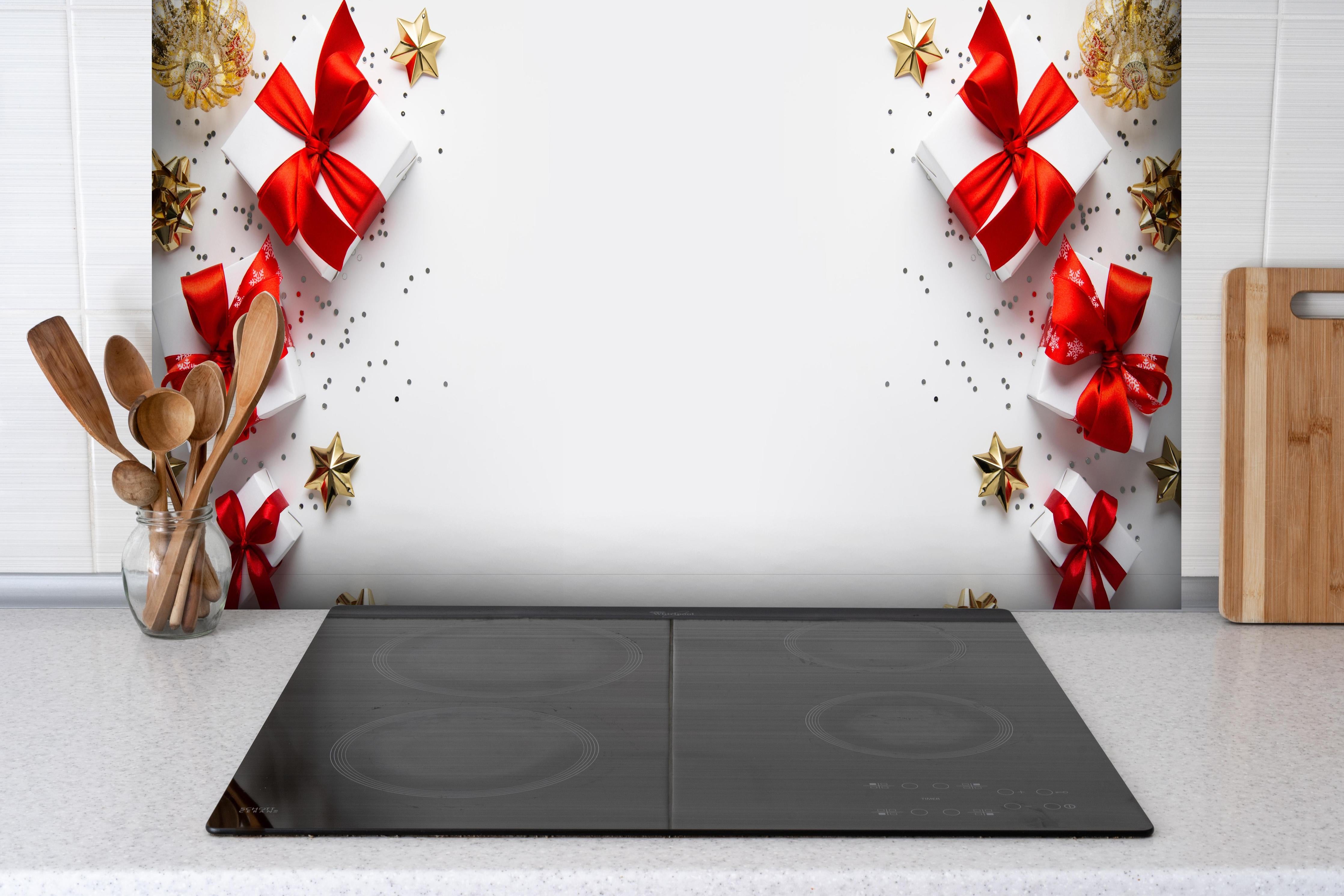 Spritzschutz - Weihnachtsgeschenke hinter einem Cerankochfeld zwischen Holz-Kochutensilien