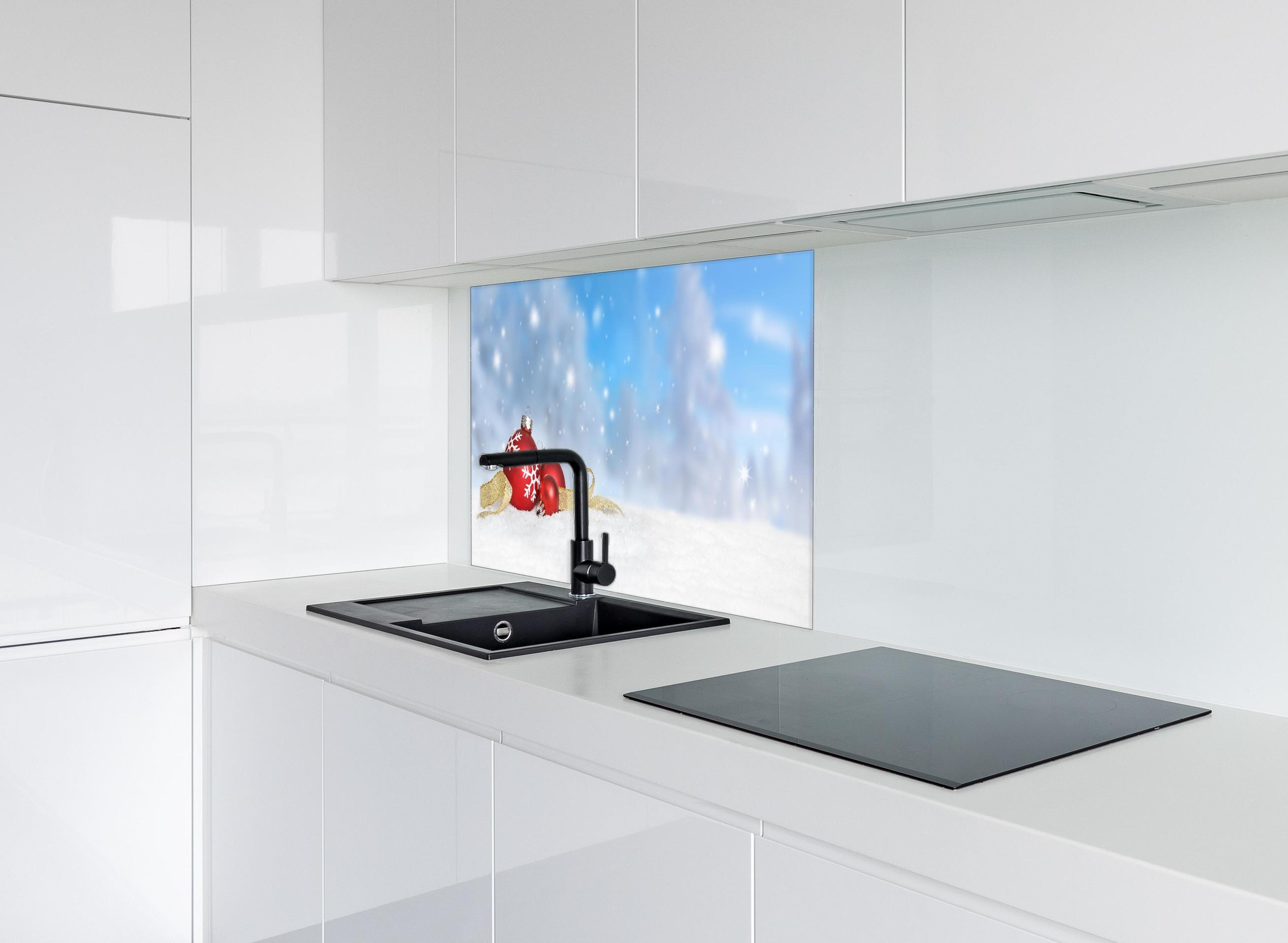 Spritzschutz - Weihnachtskugeln im Schnee hinter einem Cerankochfeld zwischen Holz-Kochutensilien