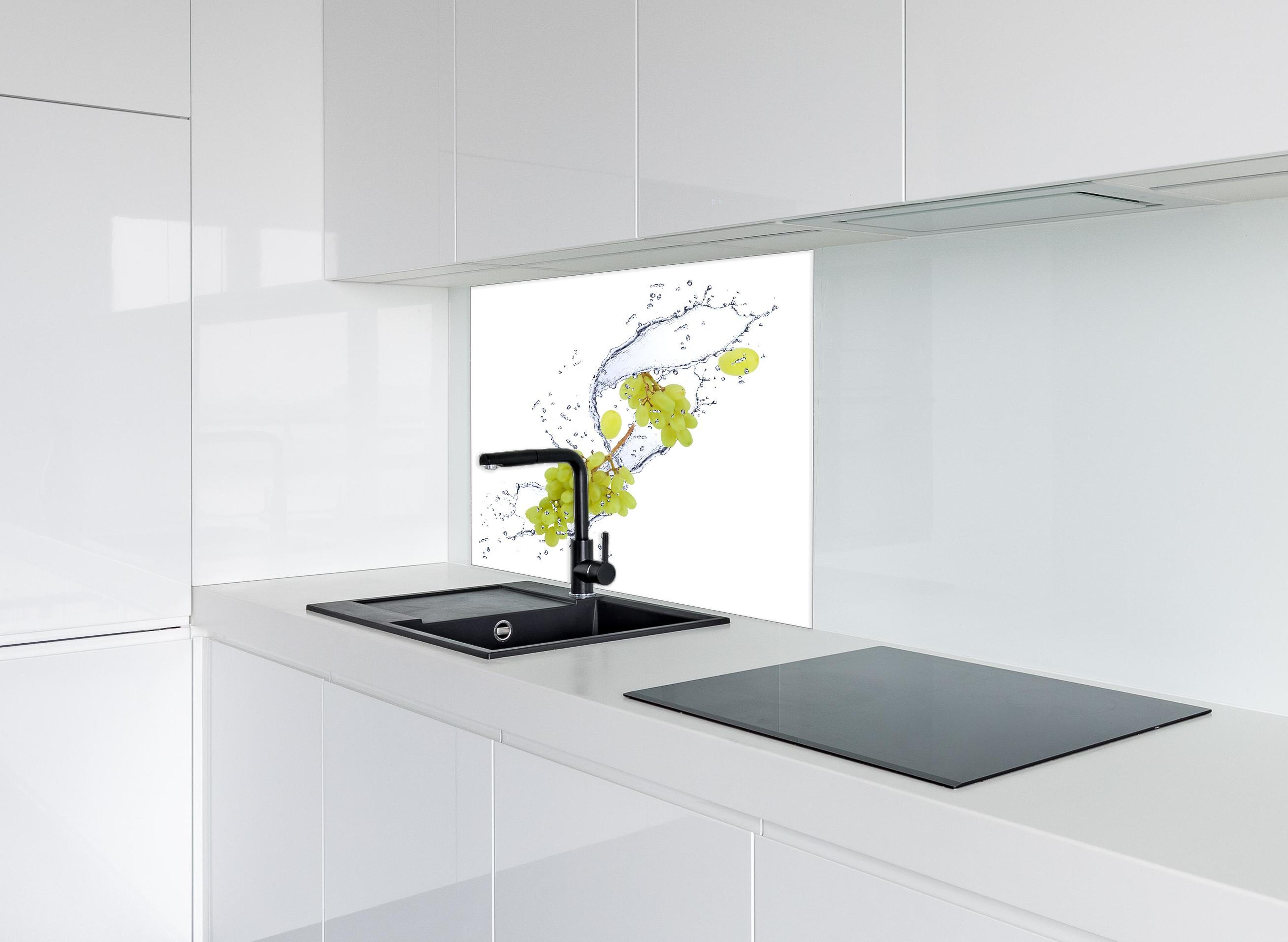 Spritzschutz - Weintraube im Wasserspritzer hinter einem Cerankochfeld zwischen Holz-Kochutensilien