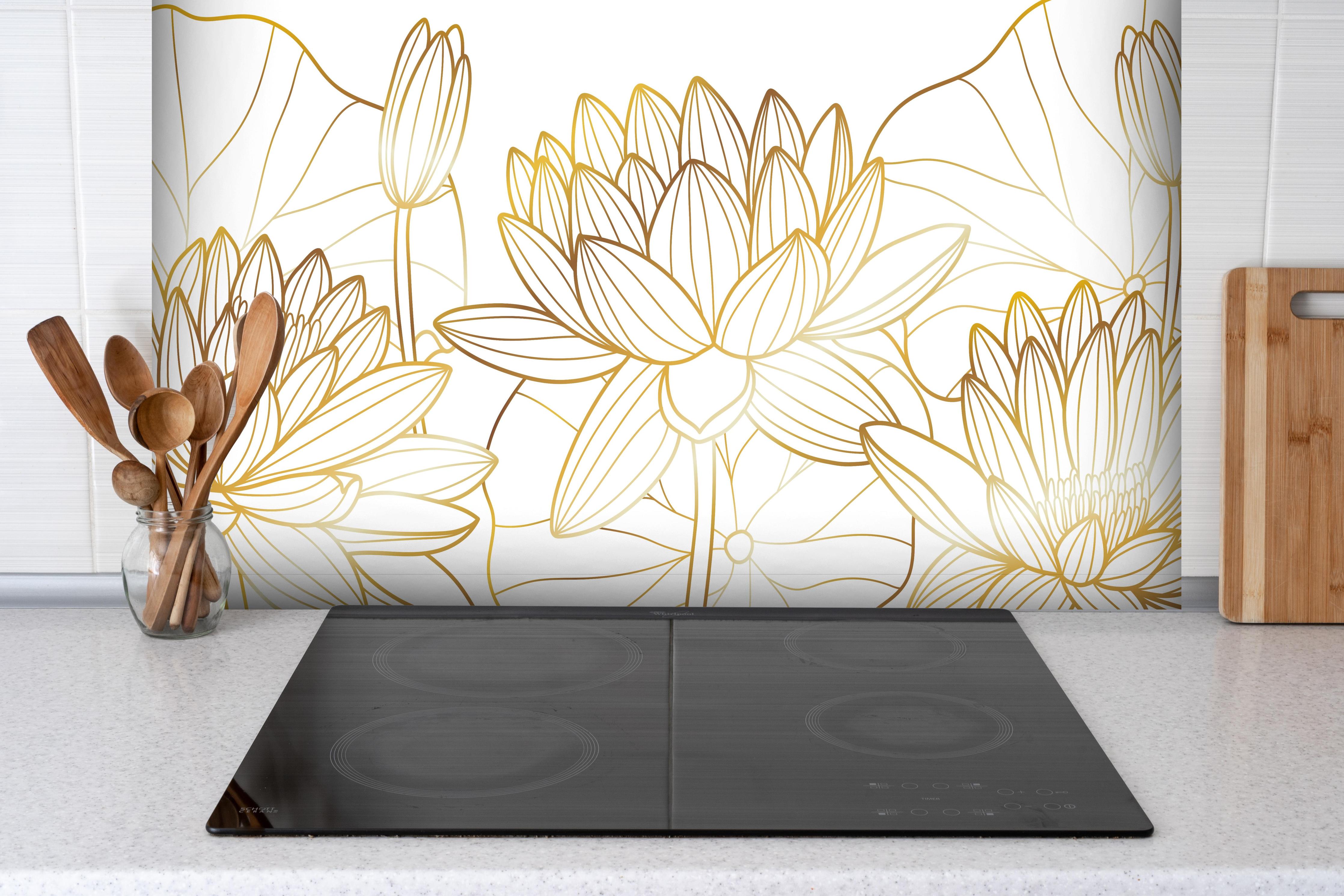 Spritzschutz - Weiß-goldene Blüten hinter einem Cerankochfeld zwischen Holz-Kochutensilien