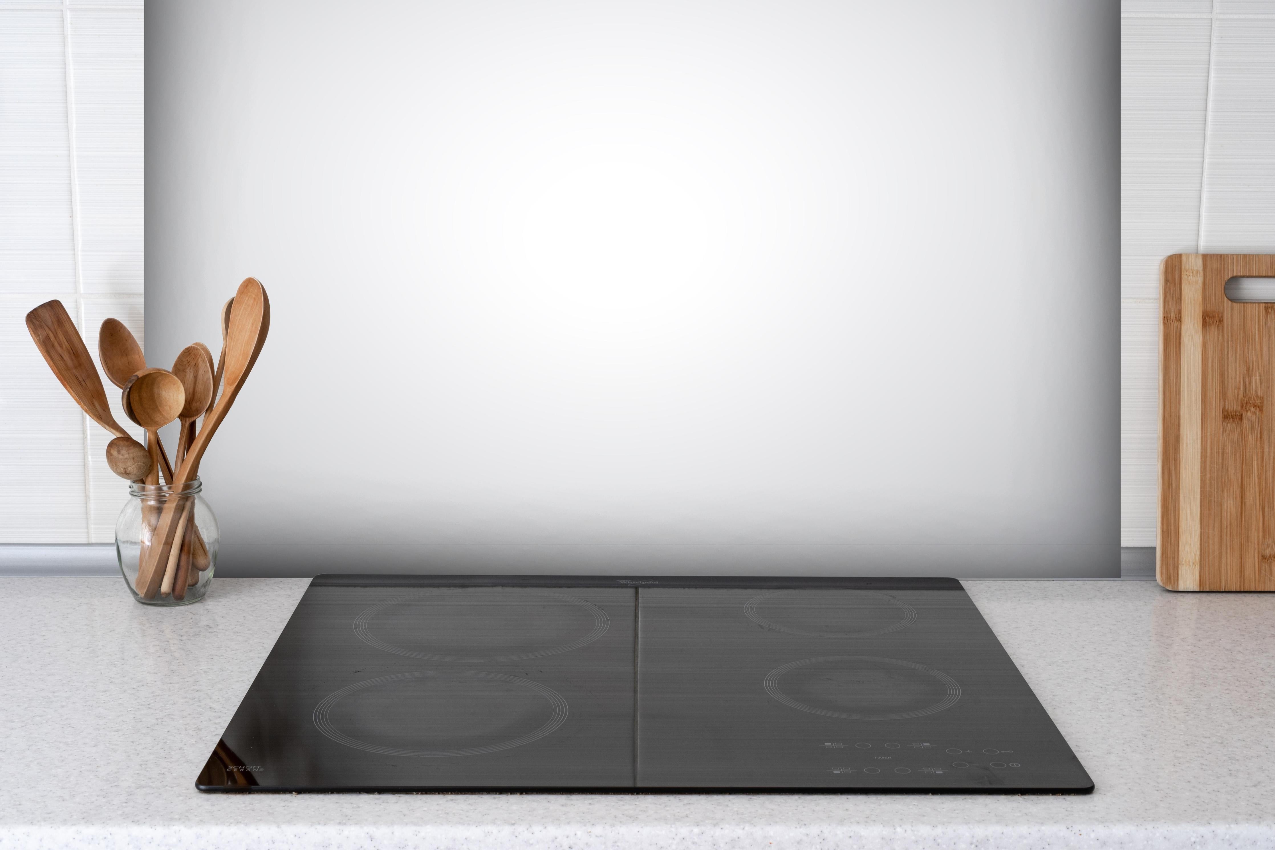 Spritzschutz - Weiß, gräuliches Muster hinter einem Cerankochfeld zwischen Holz-Kochutensilien