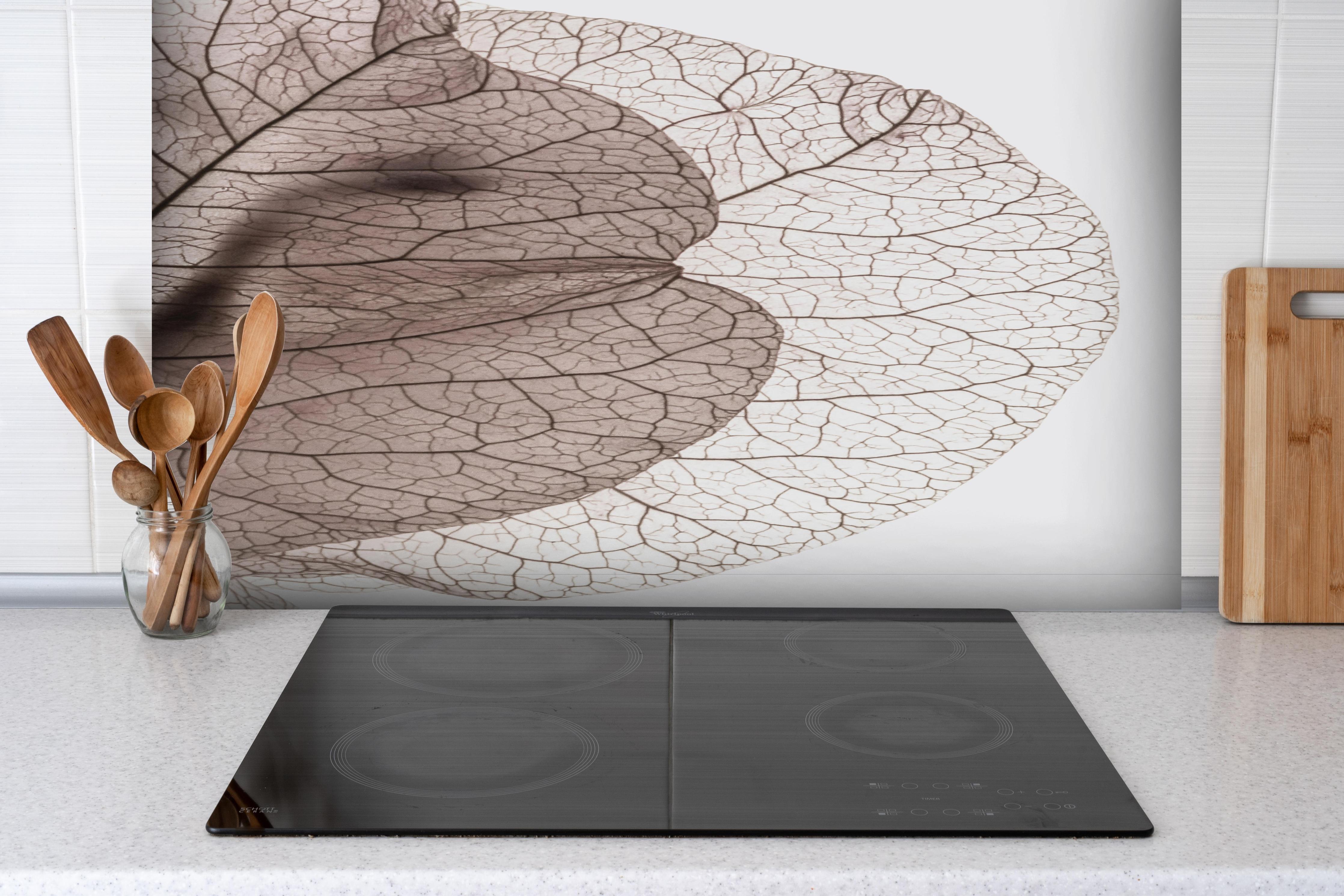 Spritzschutz - Weiße Blattadern auf Grau Makroaufnahme hinter einem Cerankochfeld zwischen Holz-Kochutensilien