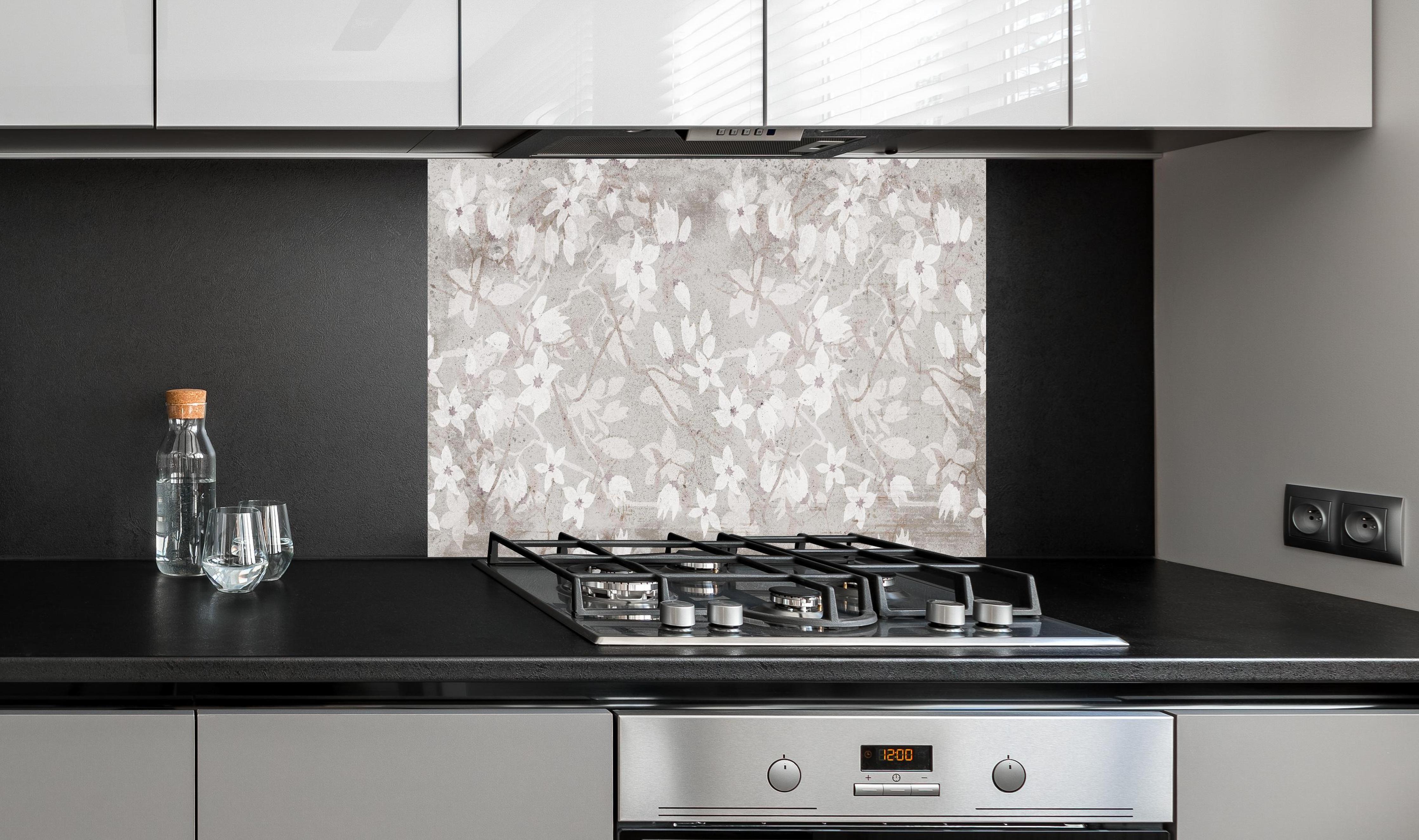 Spritzschutz - Weiße Blumen auf altem grauem Hintergrund hinter einem Cerankochfeld zwischen Holz-Kochutensilien