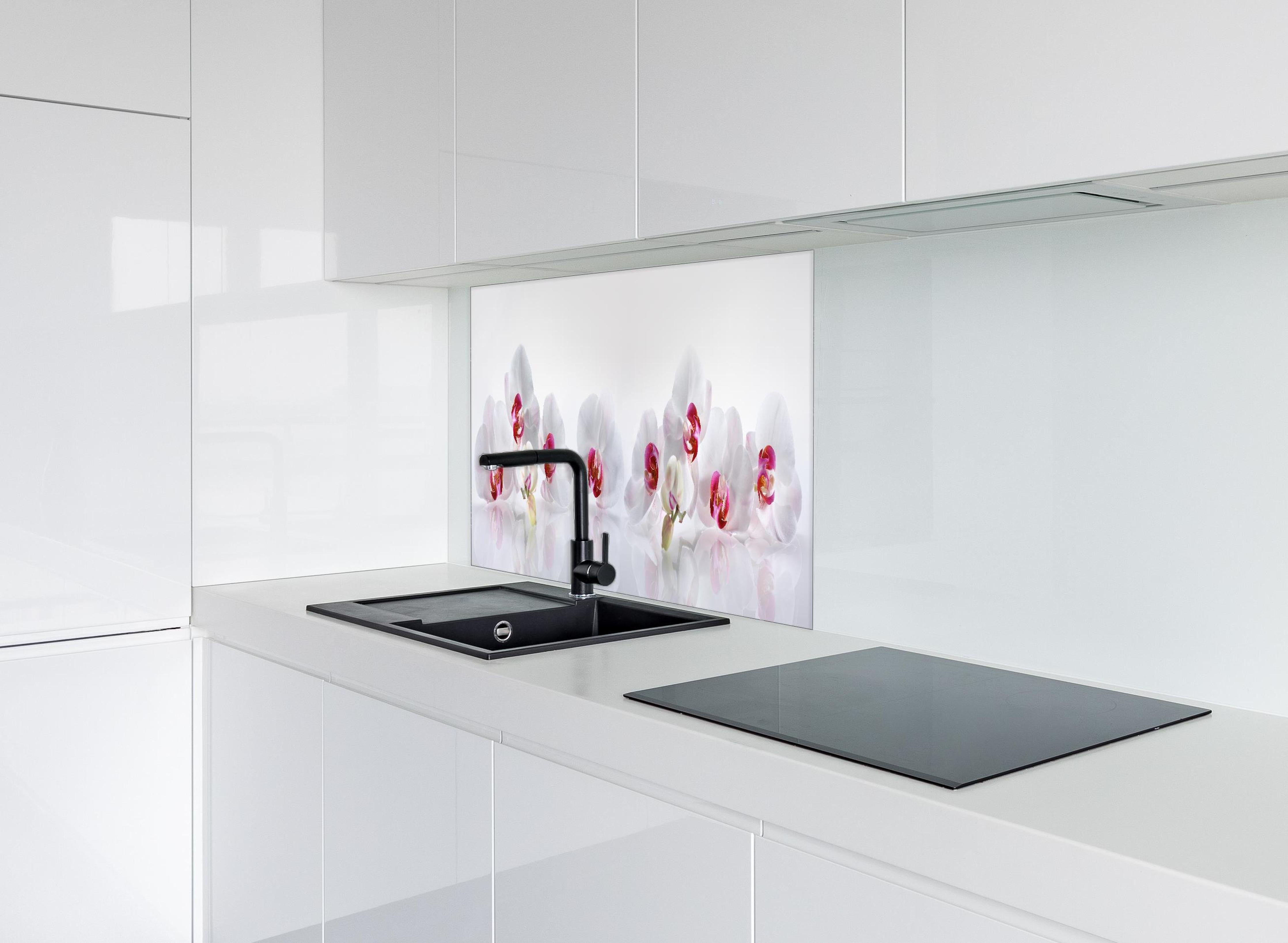 Spritzschutz - Weiße Orchideen hinter einem Cerankochfeld zwischen Holz-Kochutensilien