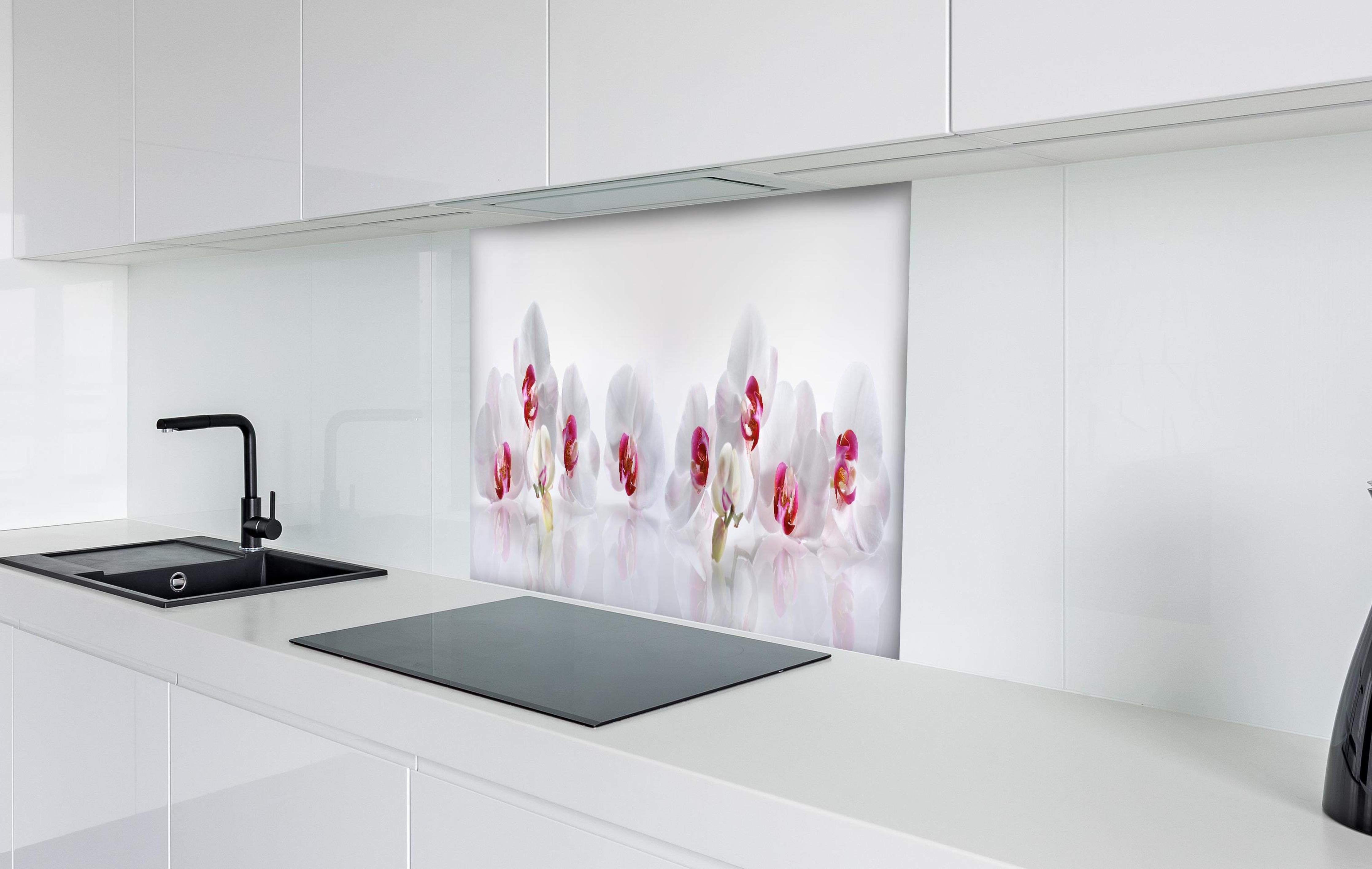 Spritzschutz - Weiße Orchideen hinter einem Cerankochfeld zwischen Holz-Kochutensilien