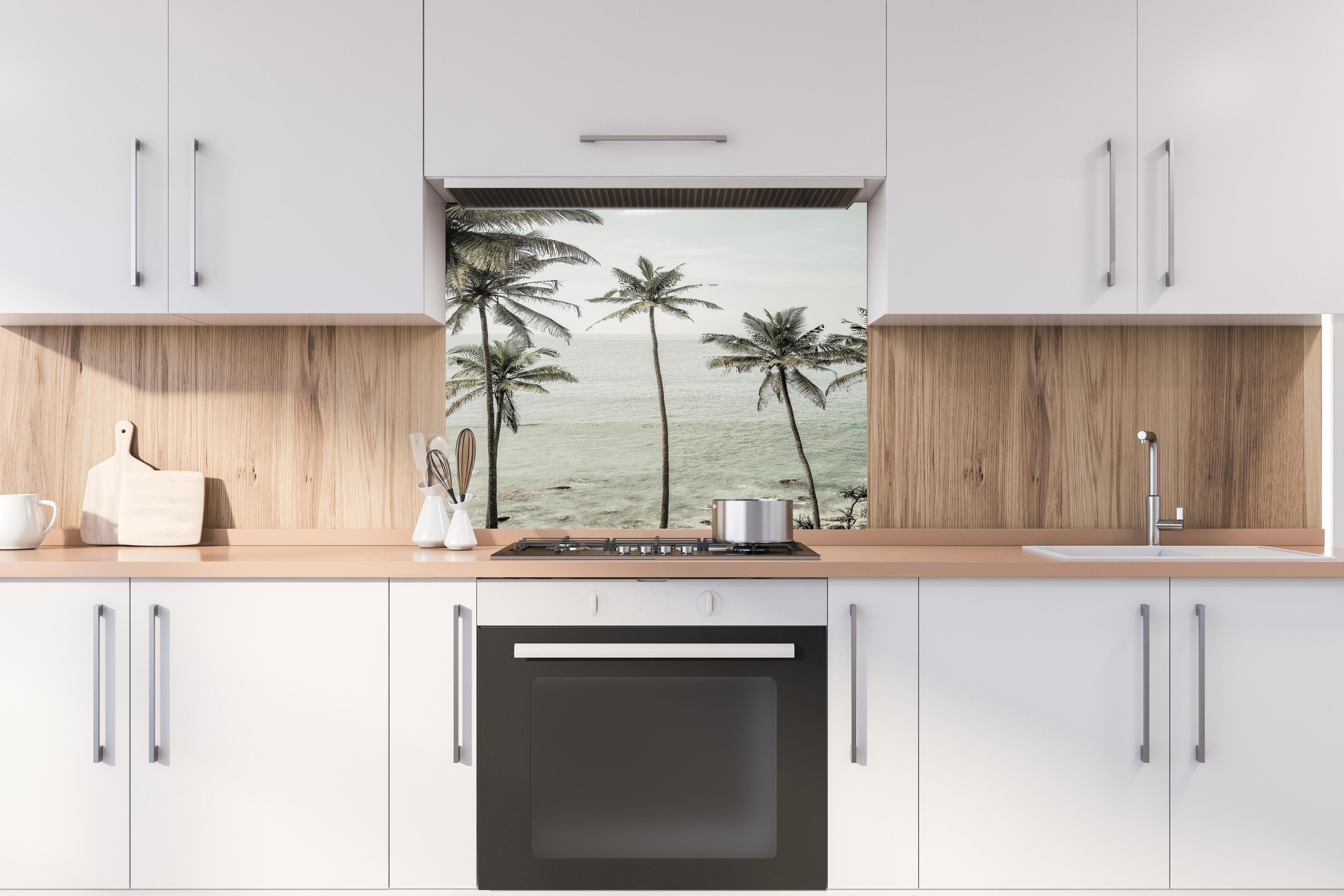 Spritzschutz - Weiße Sandstrände mit grünen Palmen hinter einem Cerankochfeld zwischen Holz-Kochutensilien