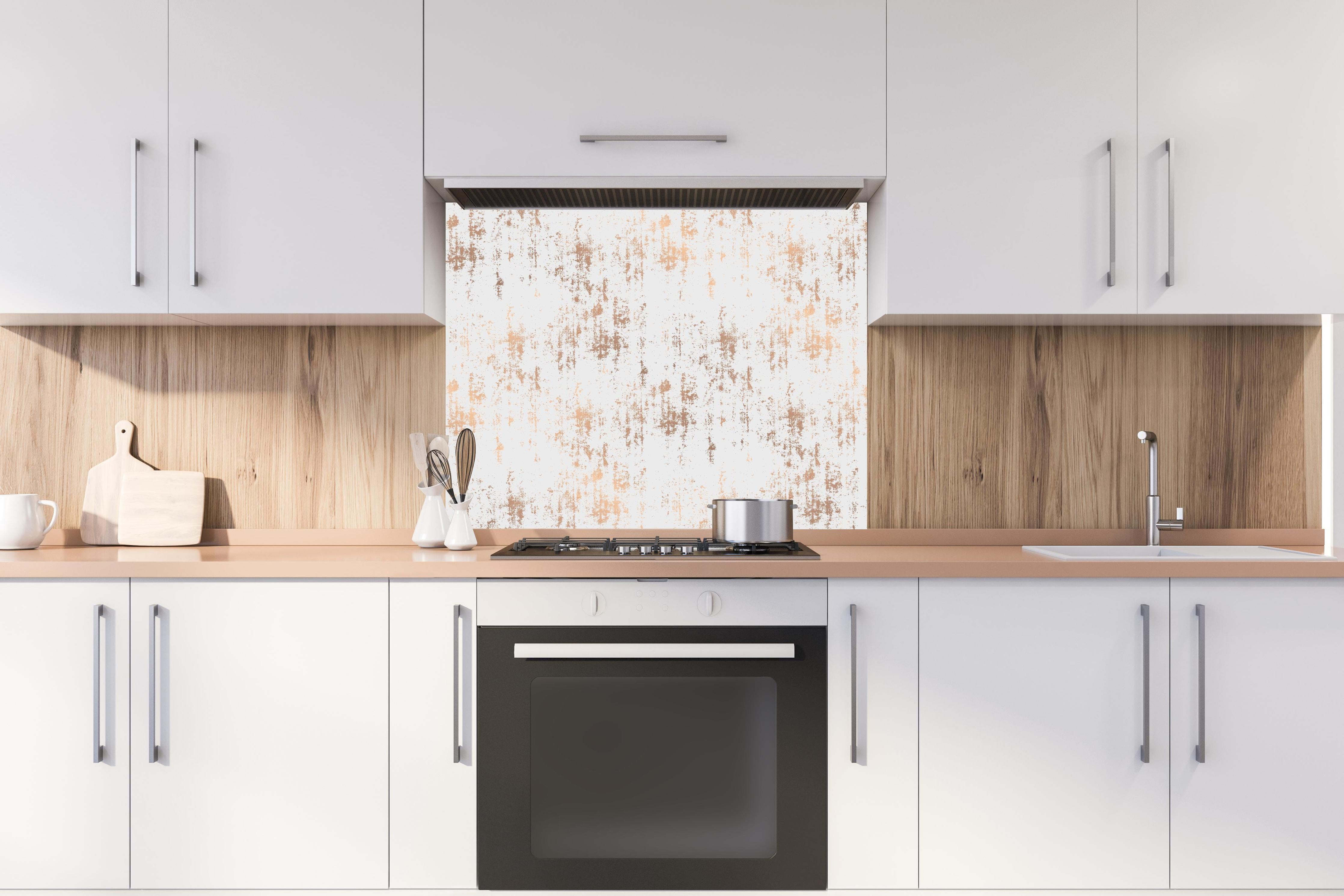 Spritzschutz - Weiße Textur mit goldenen Akzenten hinter einem Cerankochfeld zwischen Holz-Kochutensilien