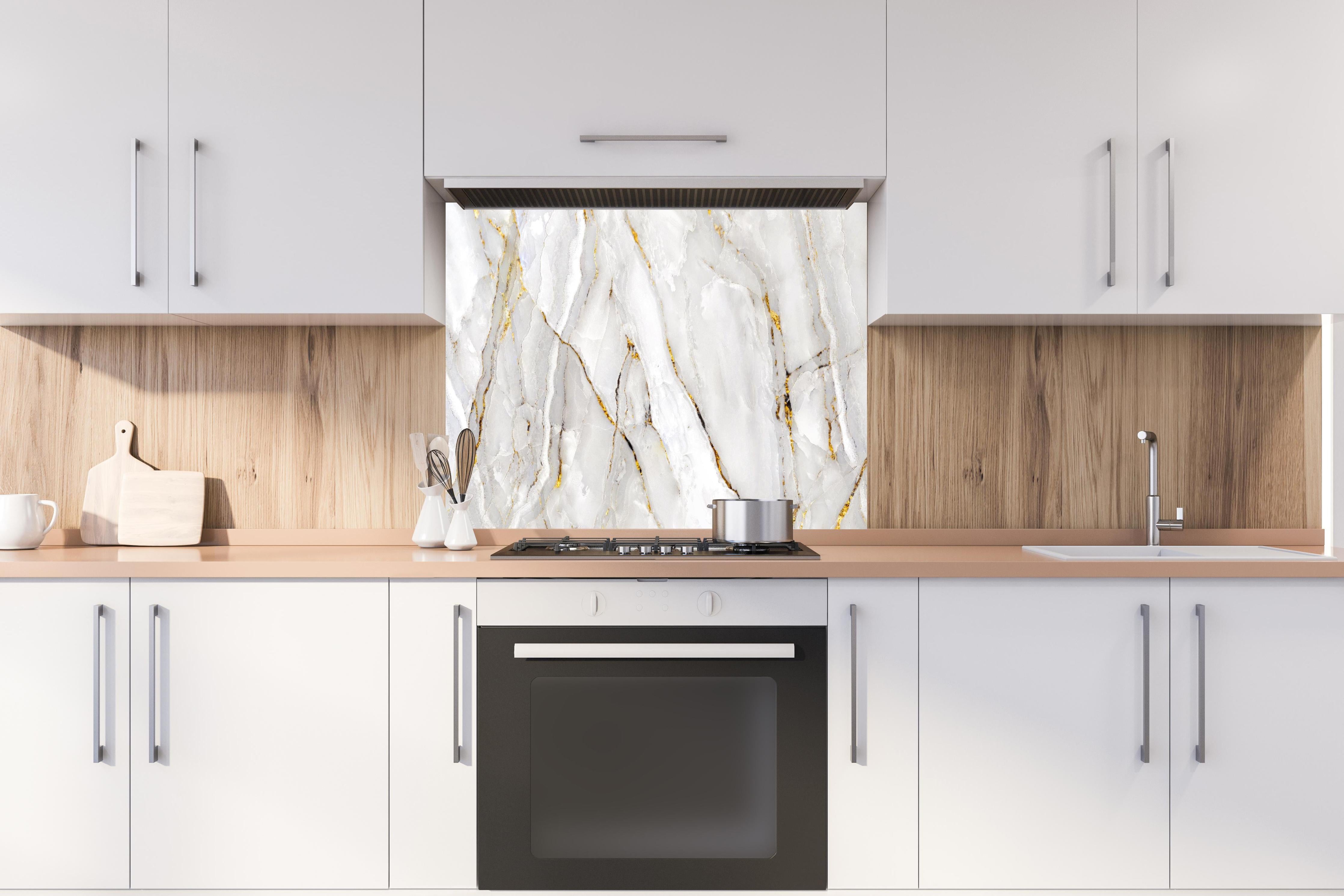 Spritzschutz - Weißer Statuario-Marmor mit goldene Adern hinter einem Cerankochfeld zwischen Holz-Kochutensilien