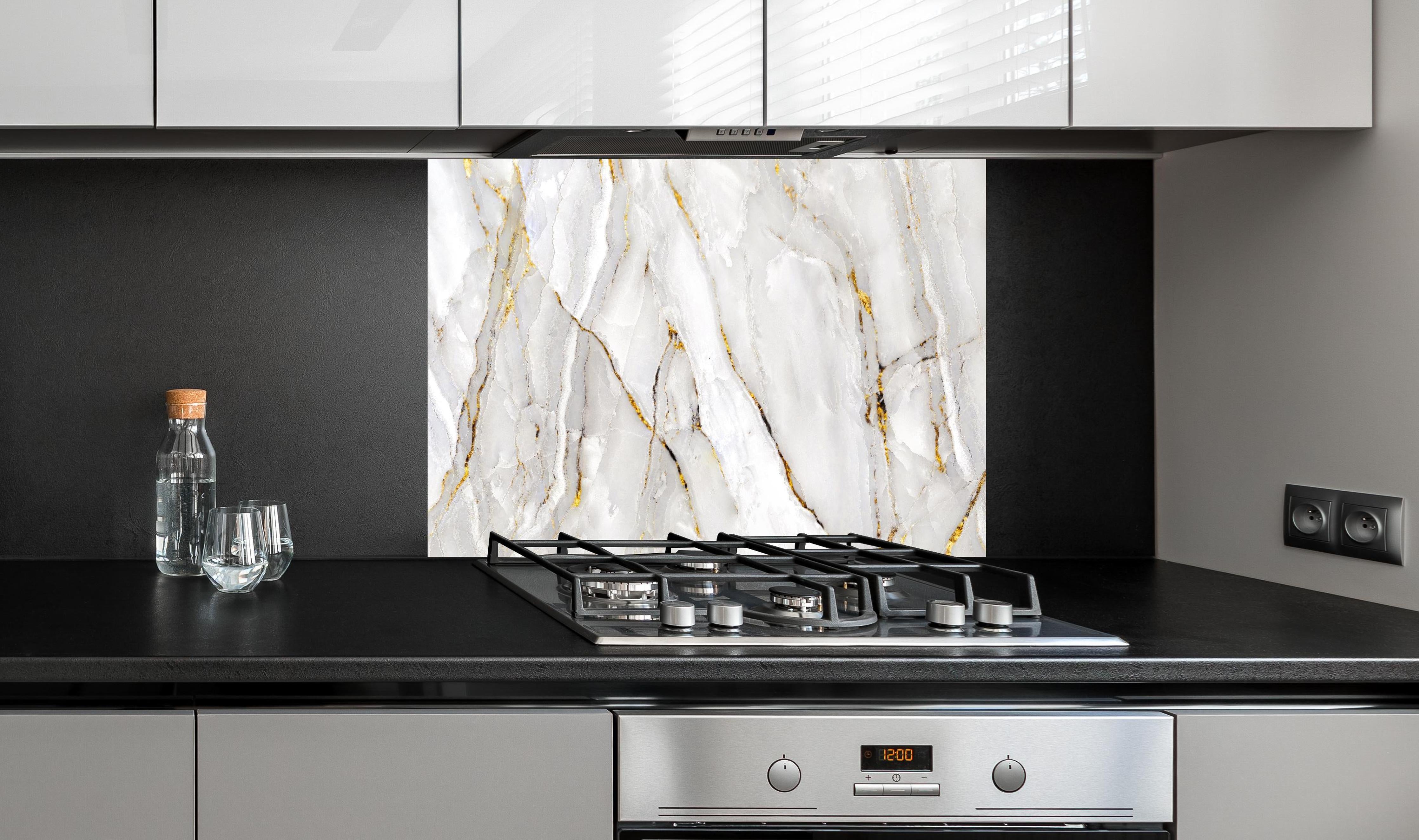 Spritzschutz - Weißer Statuario-Marmor mit goldene Adern hinter einem Cerankochfeld zwischen Holz-Kochutensilien