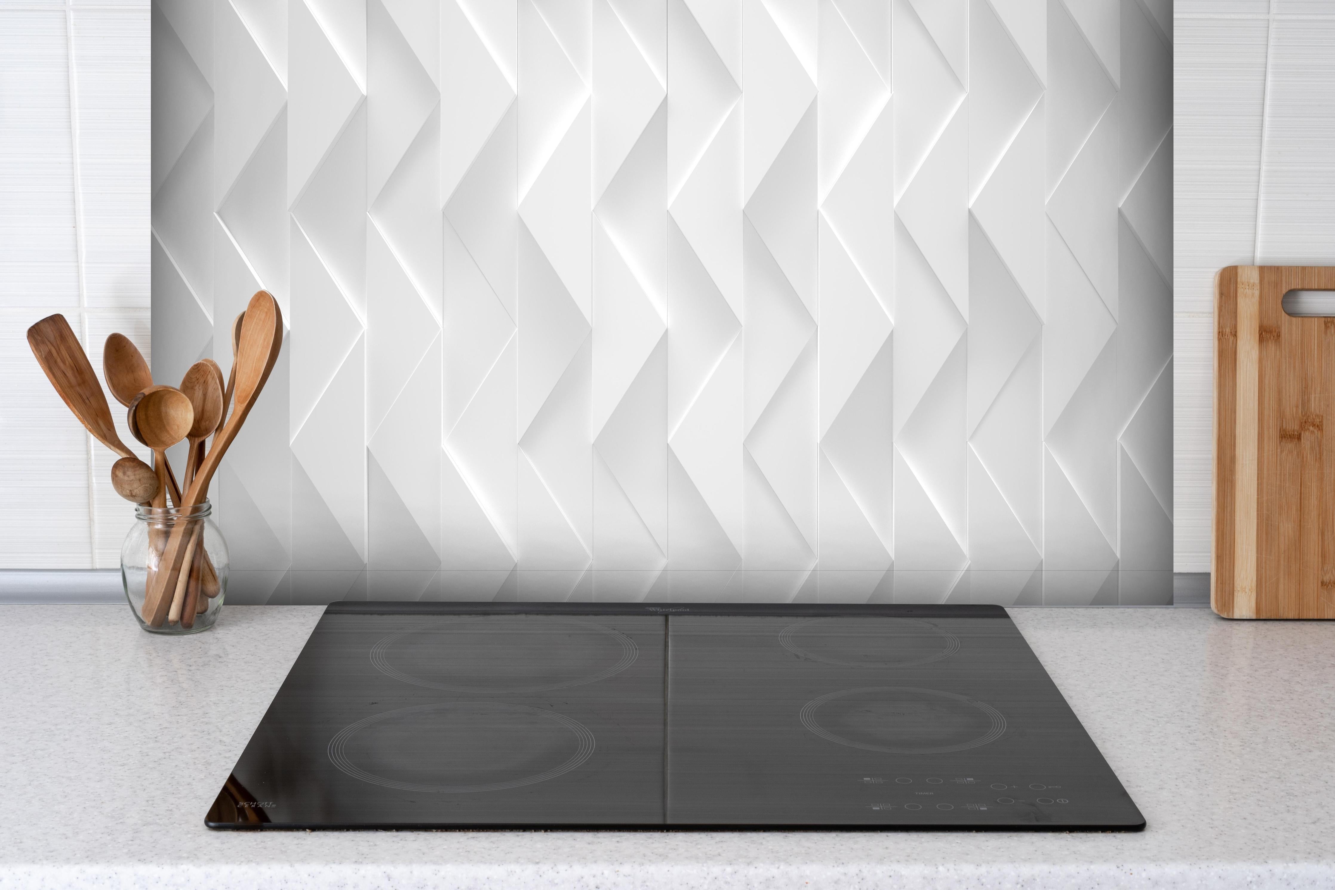 Spritzschutz - Weißes futuristisches Muster hinter einem Cerankochfeld zwischen Holz-Kochutensilien