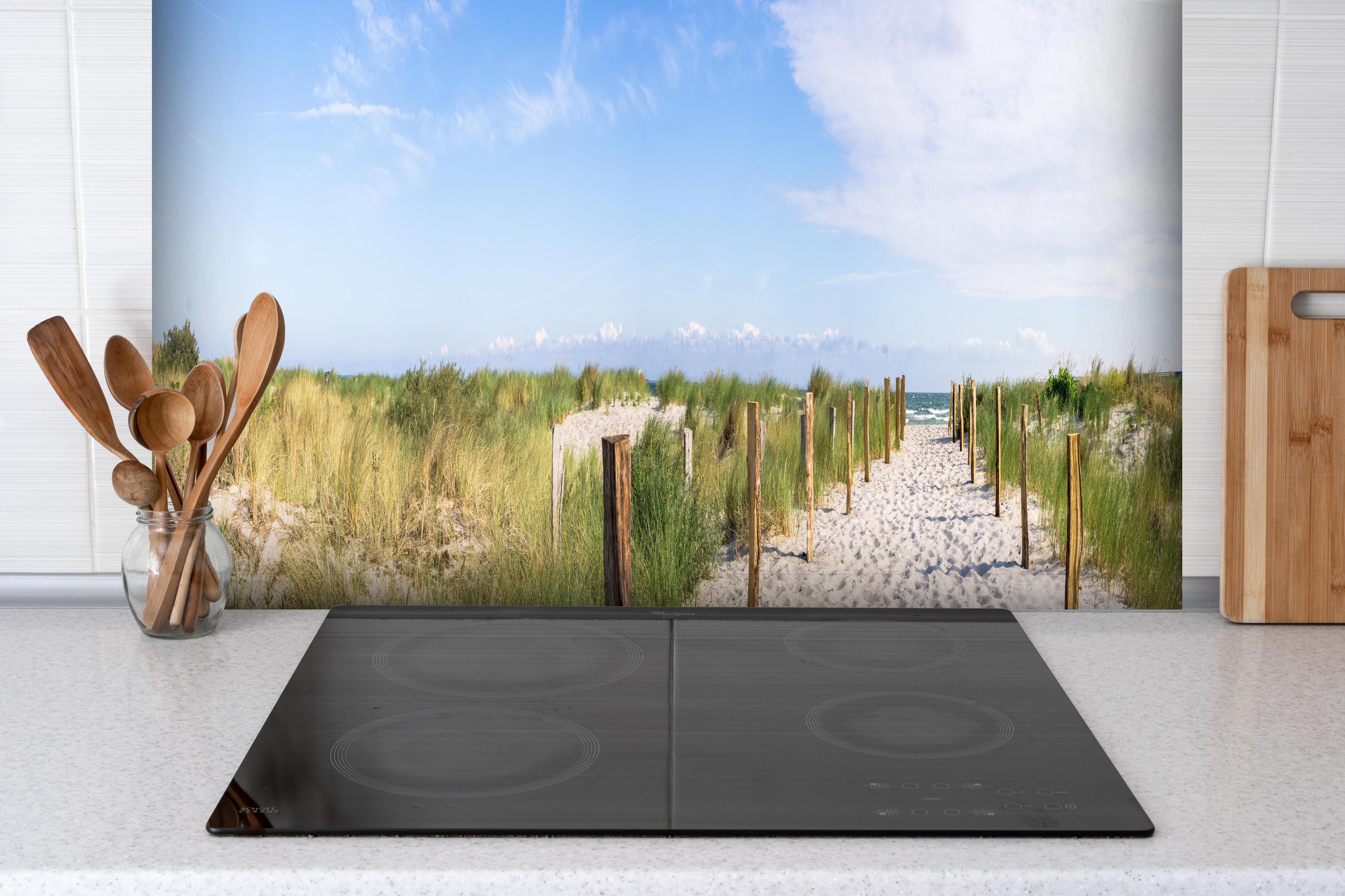 Spritzschutz - Weites Dünenpanorama Strandblick hinter einem Cerankochfeld zwischen Holz-Kochutensilien