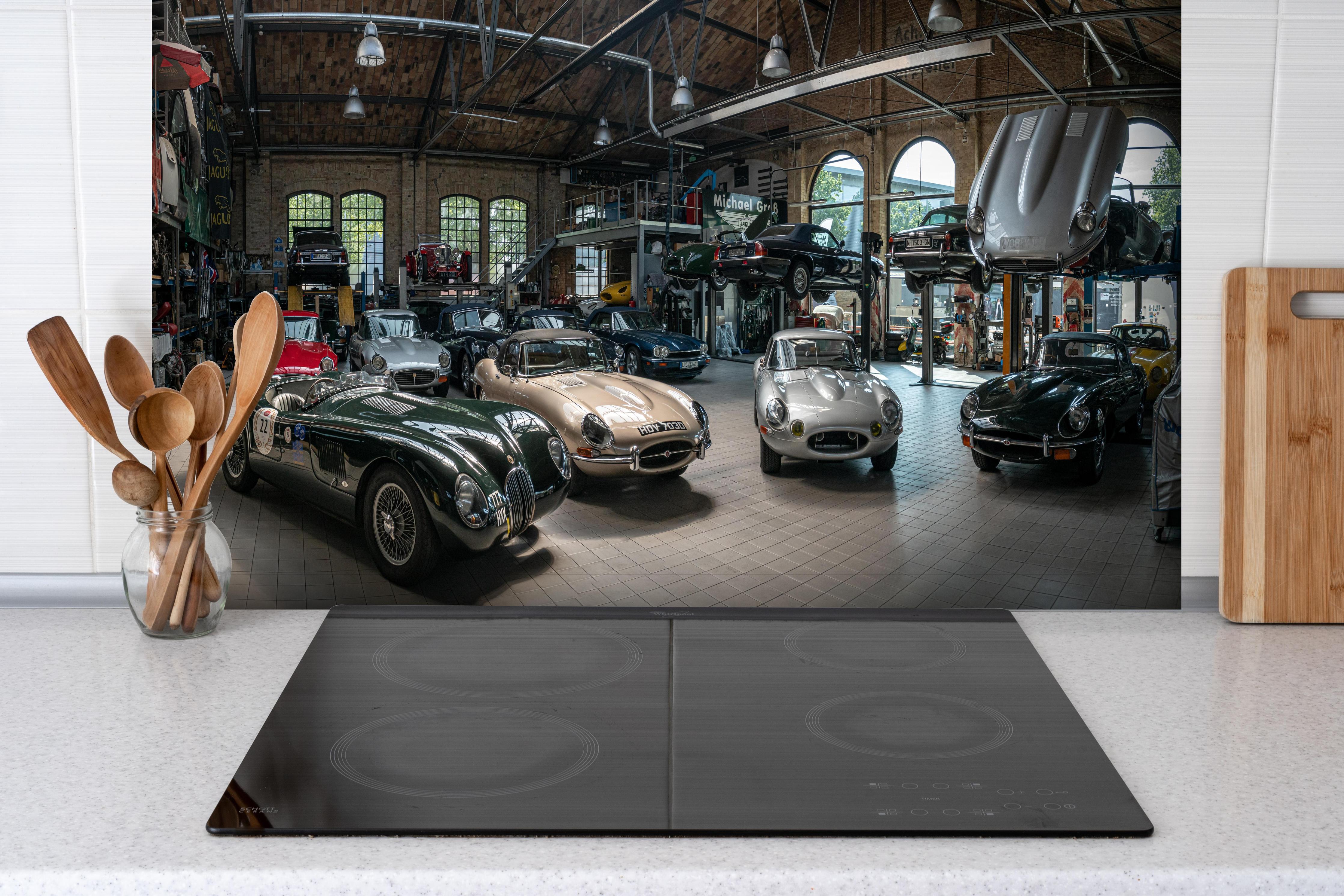 Spritzschutz - Werkstatt für die Reparatur und Wartung englischer Retro-Klassiker hinter einem Cerankochfeld zwischen Holz-Kochutensilien