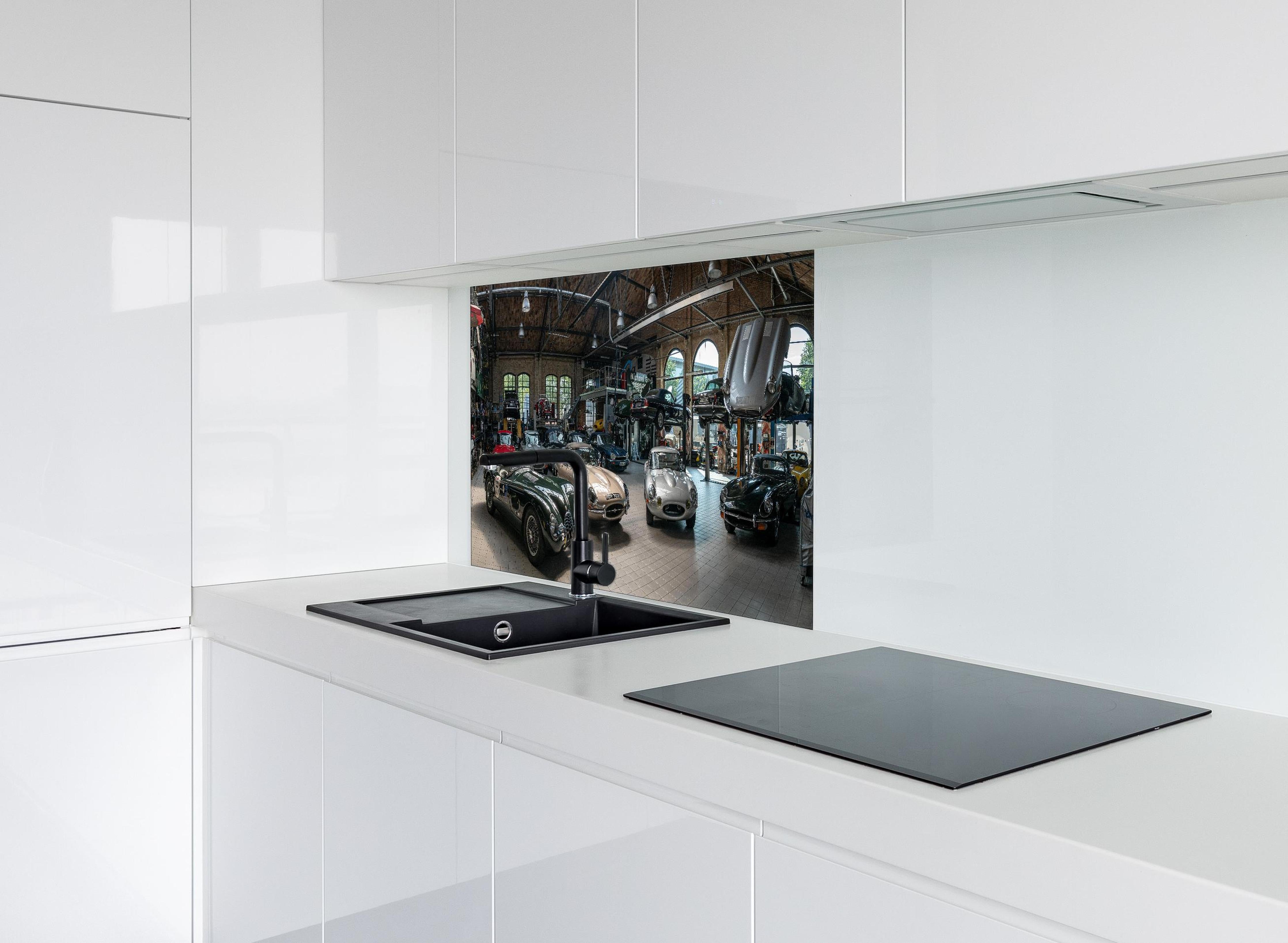 Spritzschutz - Werkstatt für die Reparatur und Wartung englischer Retro-Klassiker hinter einem Cerankochfeld zwischen Holz-Kochutensilien