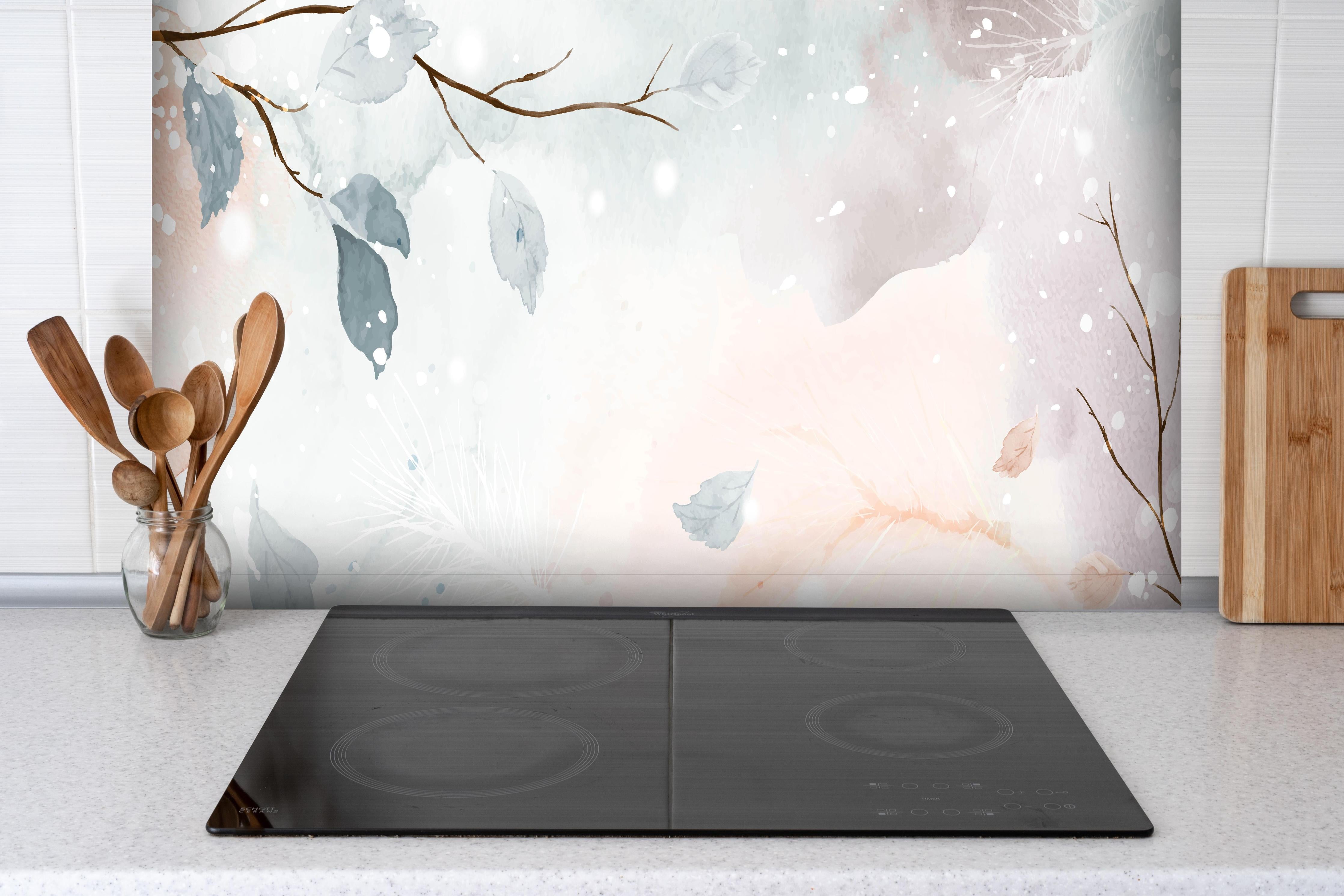 Spritzschutz - Winter Zweige in sanften Pastellfarben hinter einem Cerankochfeld zwischen Holz-Kochutensilien