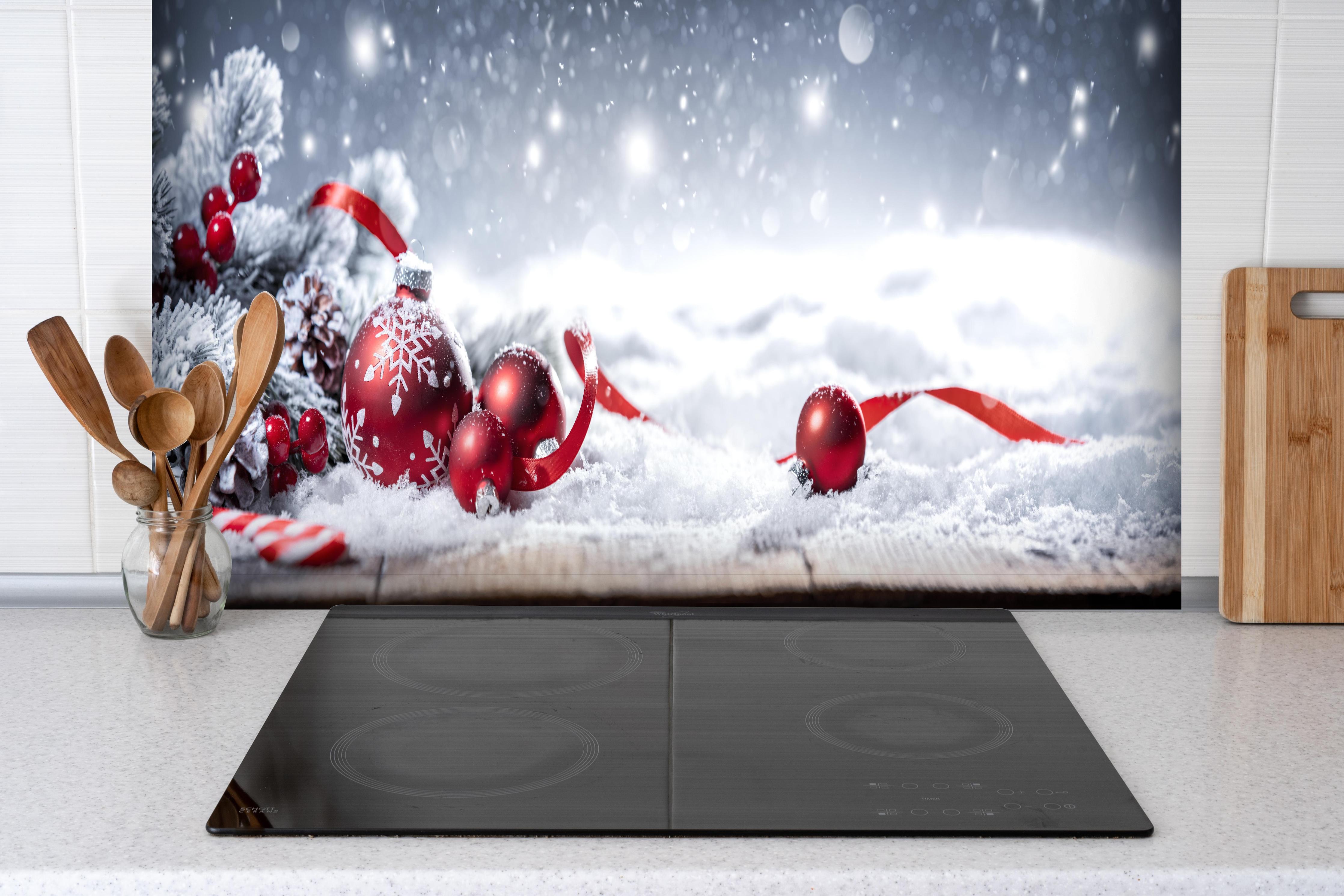 Spritzschutz - Winterliche Weihnachtsdekoration hinter einem Cerankochfeld zwischen Holz-Kochutensilien