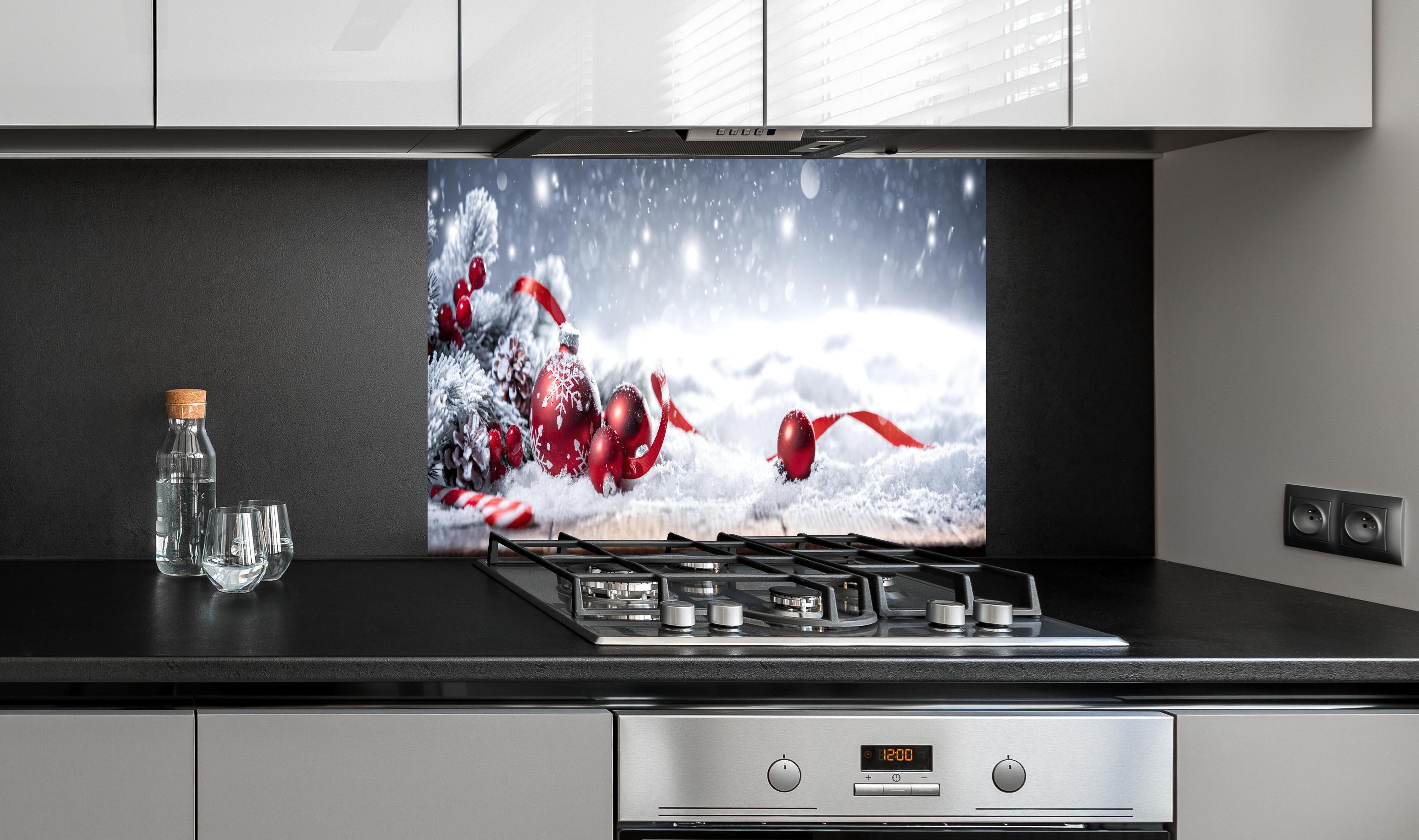 Spritzschutz - Winterliche Weihnachtsdekoration hinter einem Cerankochfeld zwischen Holz-Kochutensilien