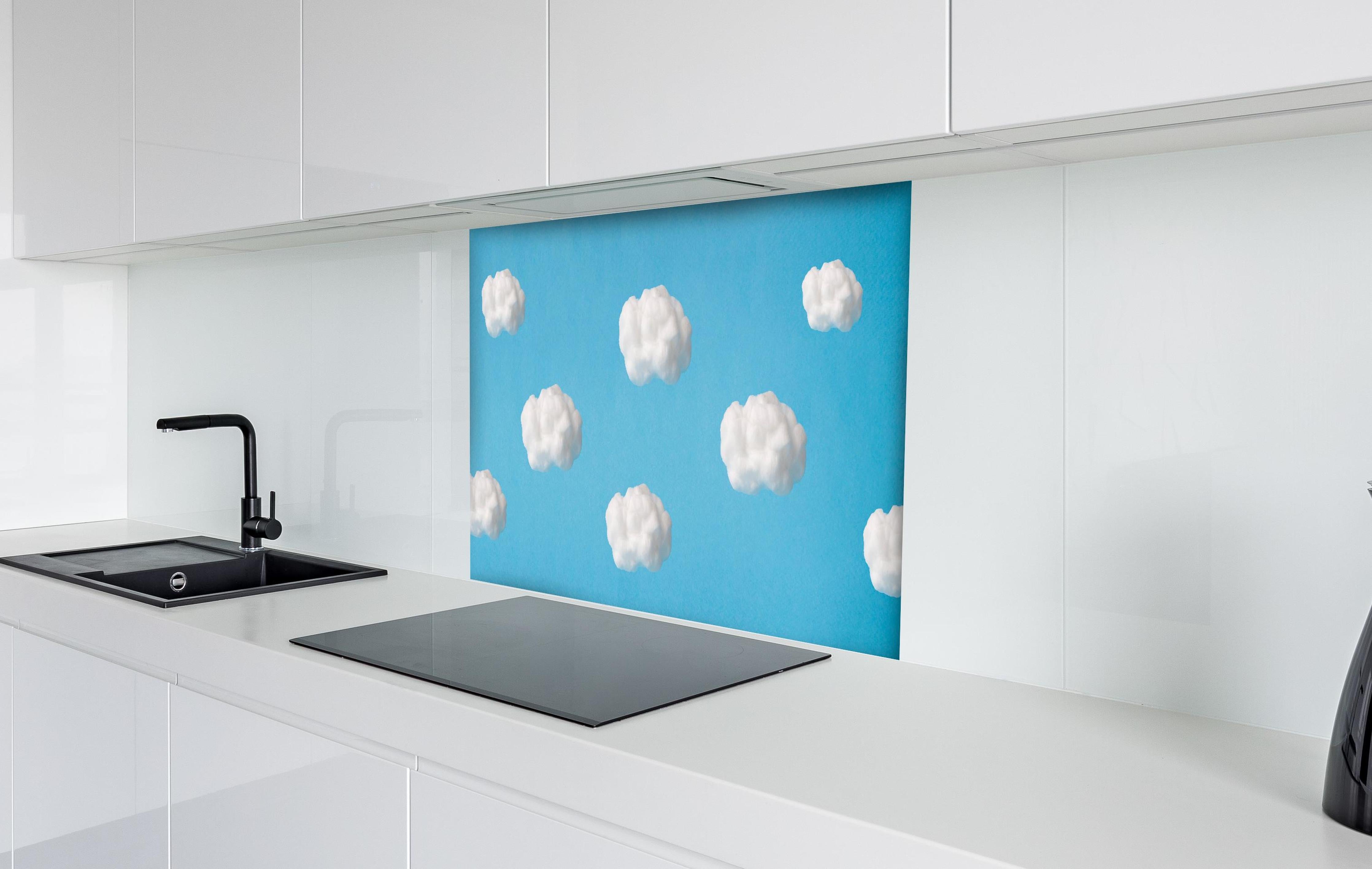 Spritzschutz - Wolke aus Watte auf himmelblauem Hintergrund hinter einem Cerankochfeld zwischen Holz-Kochutensilien