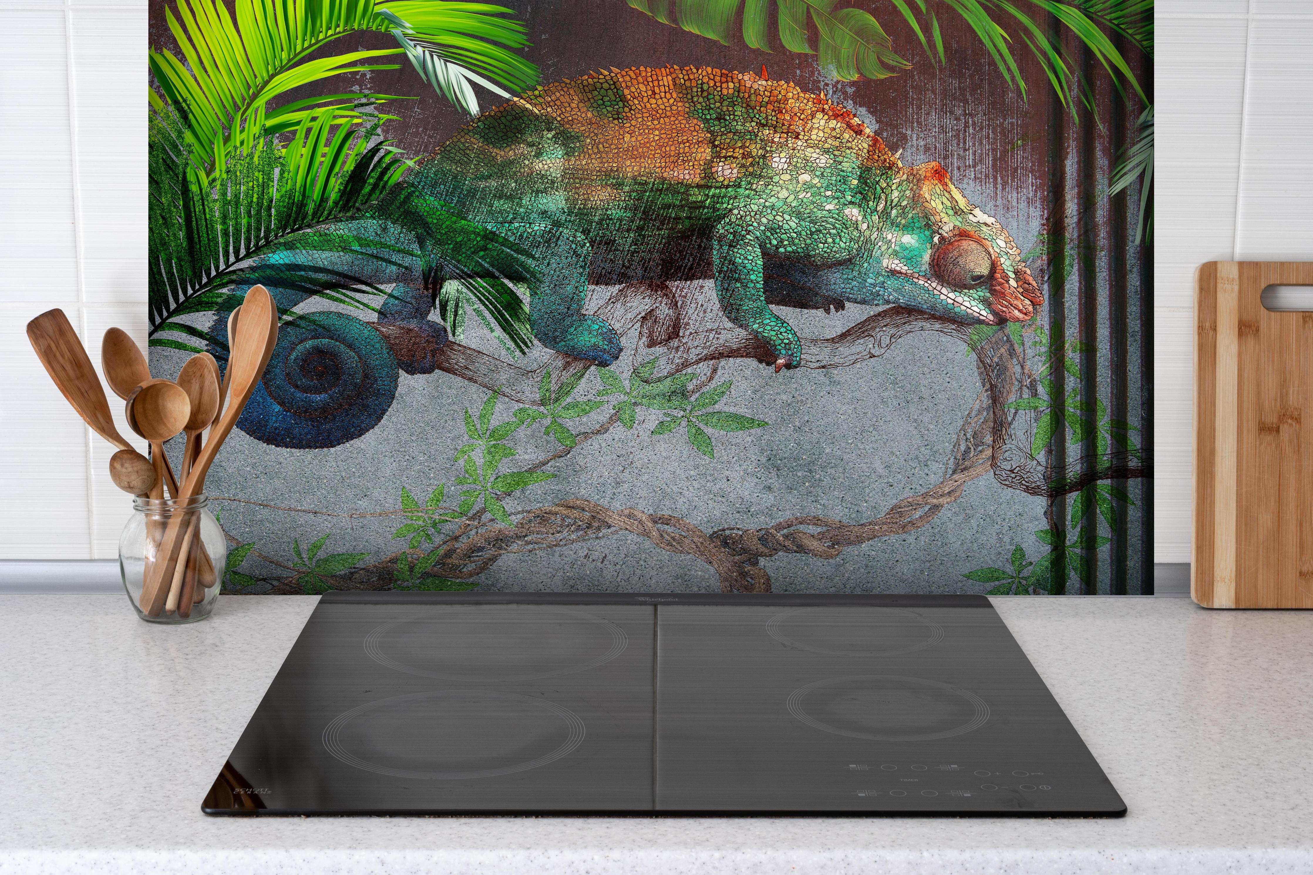 Spritzschutz - Wunderschöner Chamäleon hinter einem Cerankochfeld zwischen Holz-Kochutensilien