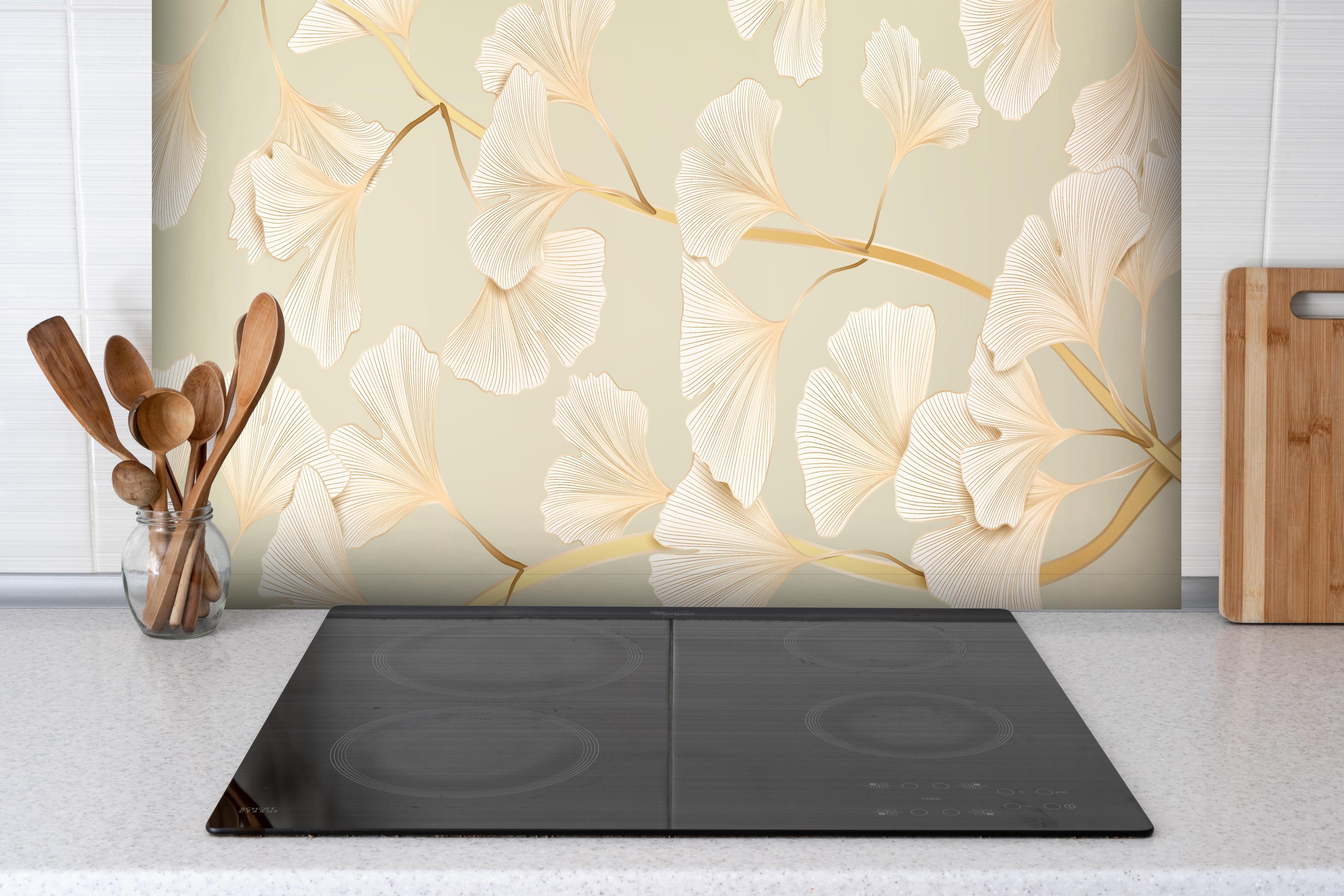Spritzschutz - Zarte Ginkgo-Blatt-Muster in Pastellbeige hinter einem Cerankochfeld zwischen Holz-Kochutensilien