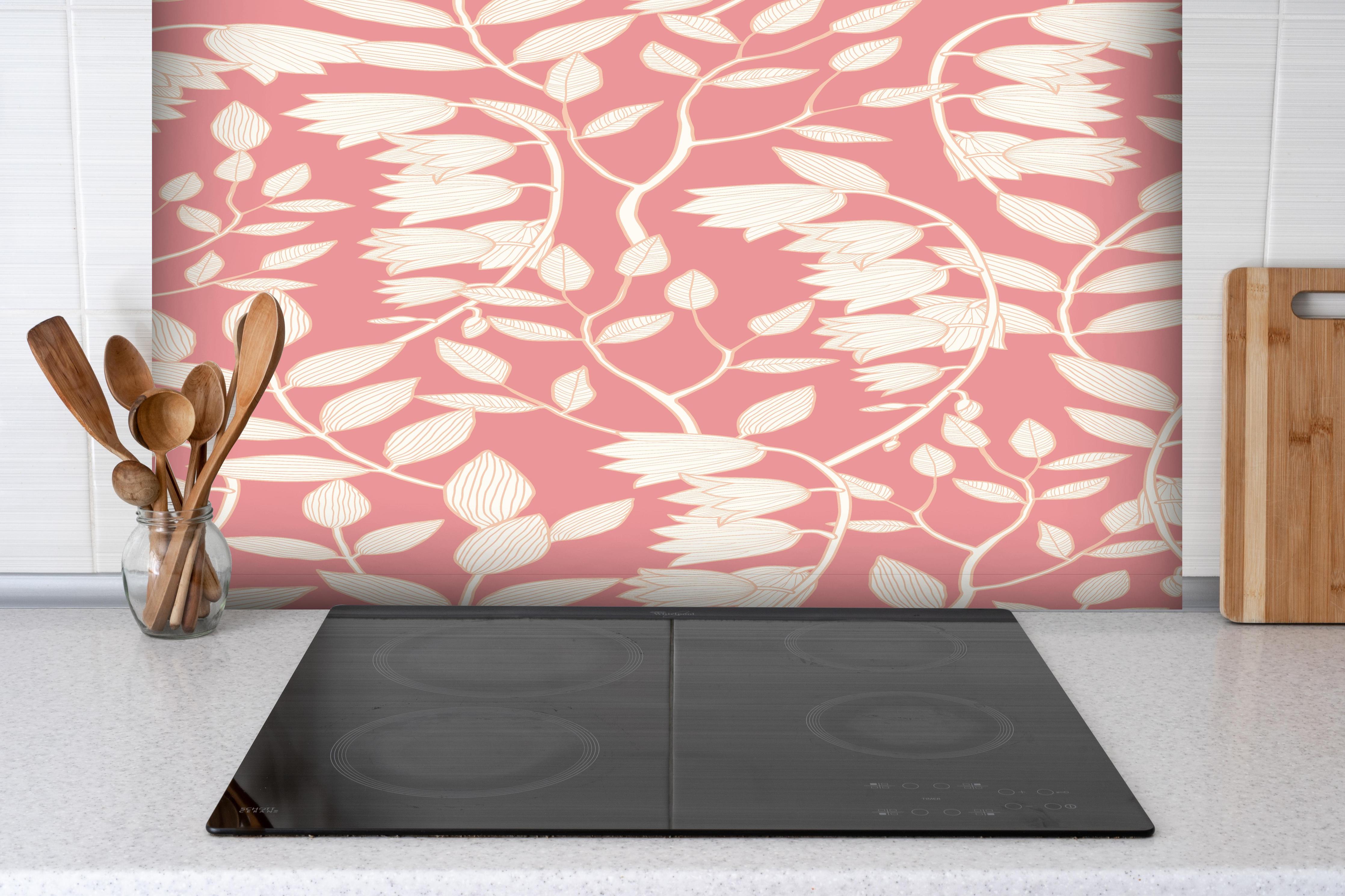 Spritzschutz - Zartrosa Tapete mit elegantem Blattmuster hinter einem Cerankochfeld zwischen Holz-Kochutensilien
