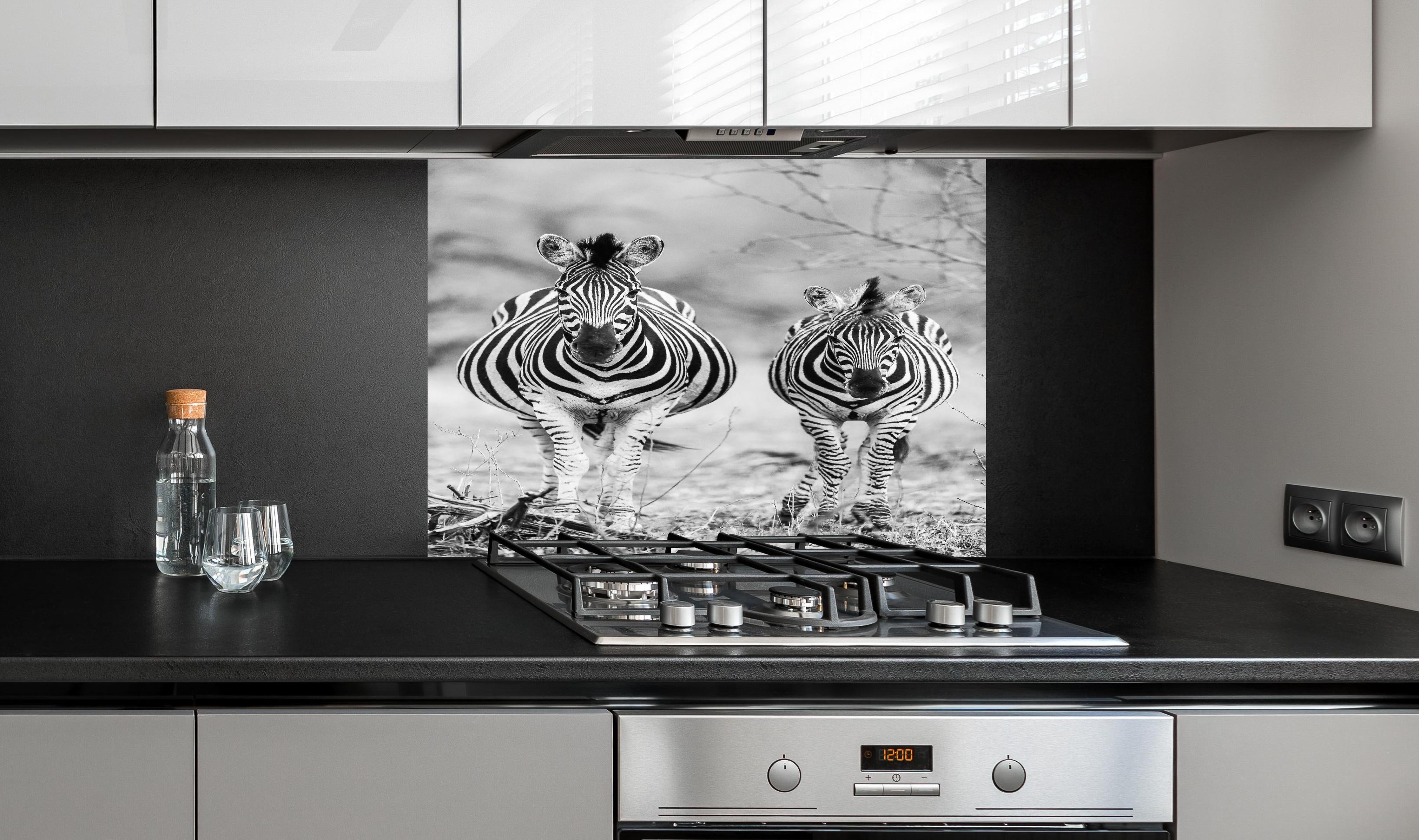Spritzschutz - Zebrapaar in Schwarz-Weiß-Kontrast hinter einem Cerankochfeld zwischen Holz-Kochutensilien