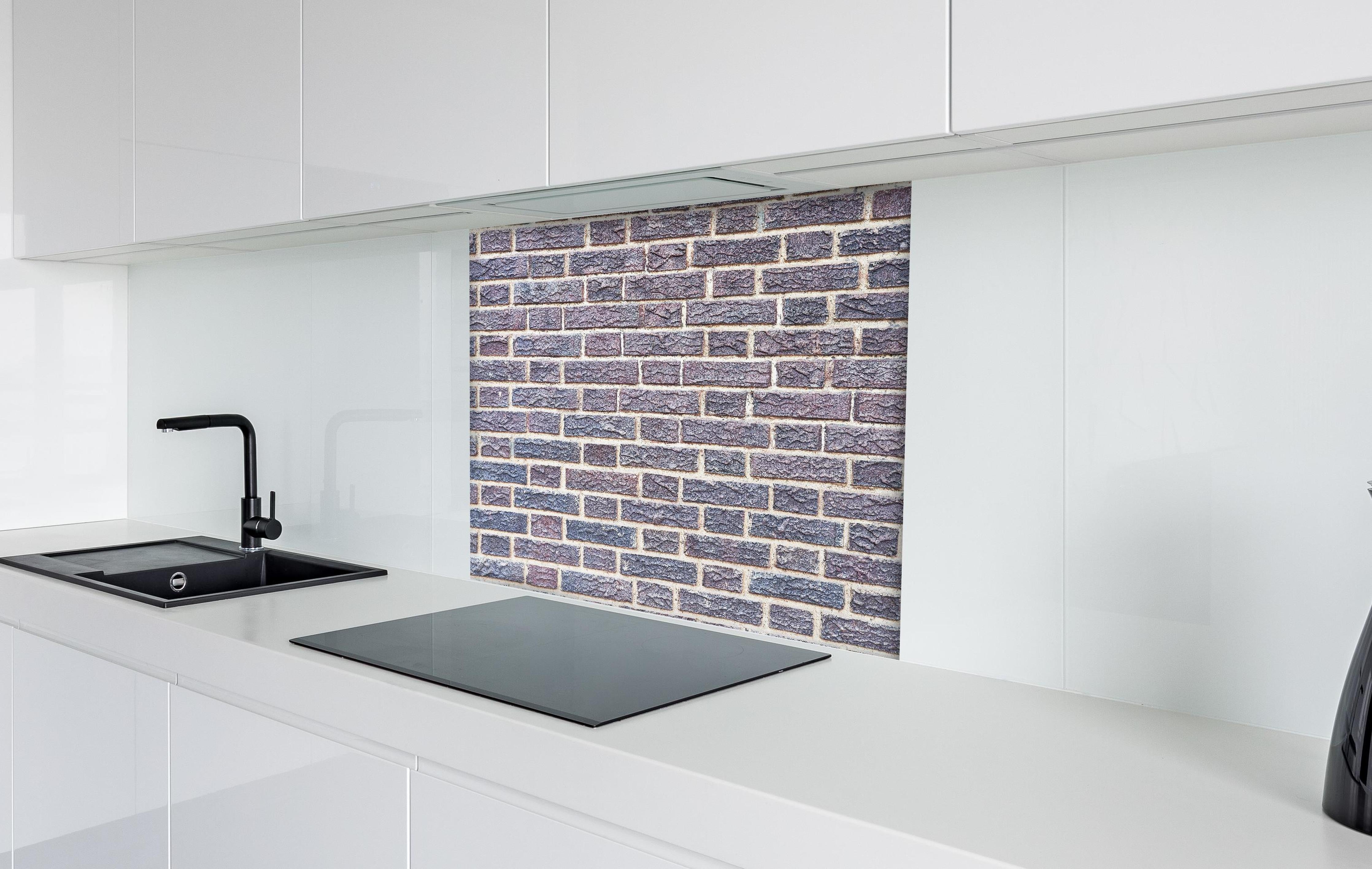 Spritzschutz - Zementmauertextur mit rissigen Fliesen hinter einem Cerankochfeld zwischen Holz-Kochutensilien