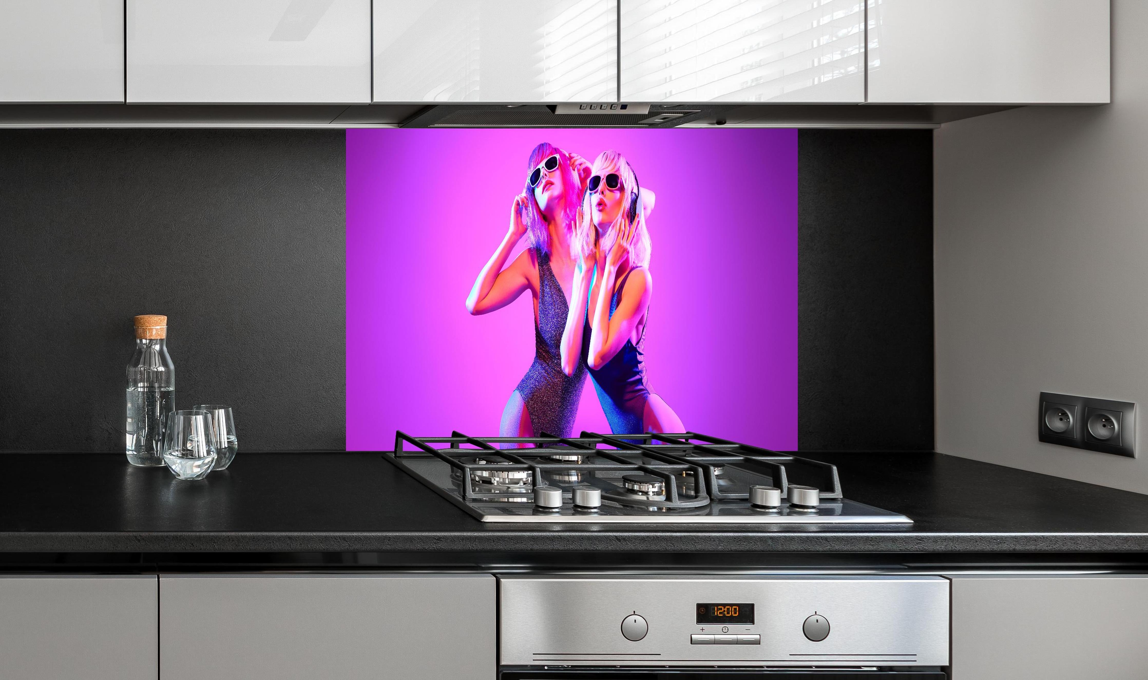 Spritzschutz - Zwei DJ Fitness Frau in bunten Neonlicht. Disco hinter einem Cerankochfeld zwischen Holz-Kochutensilien