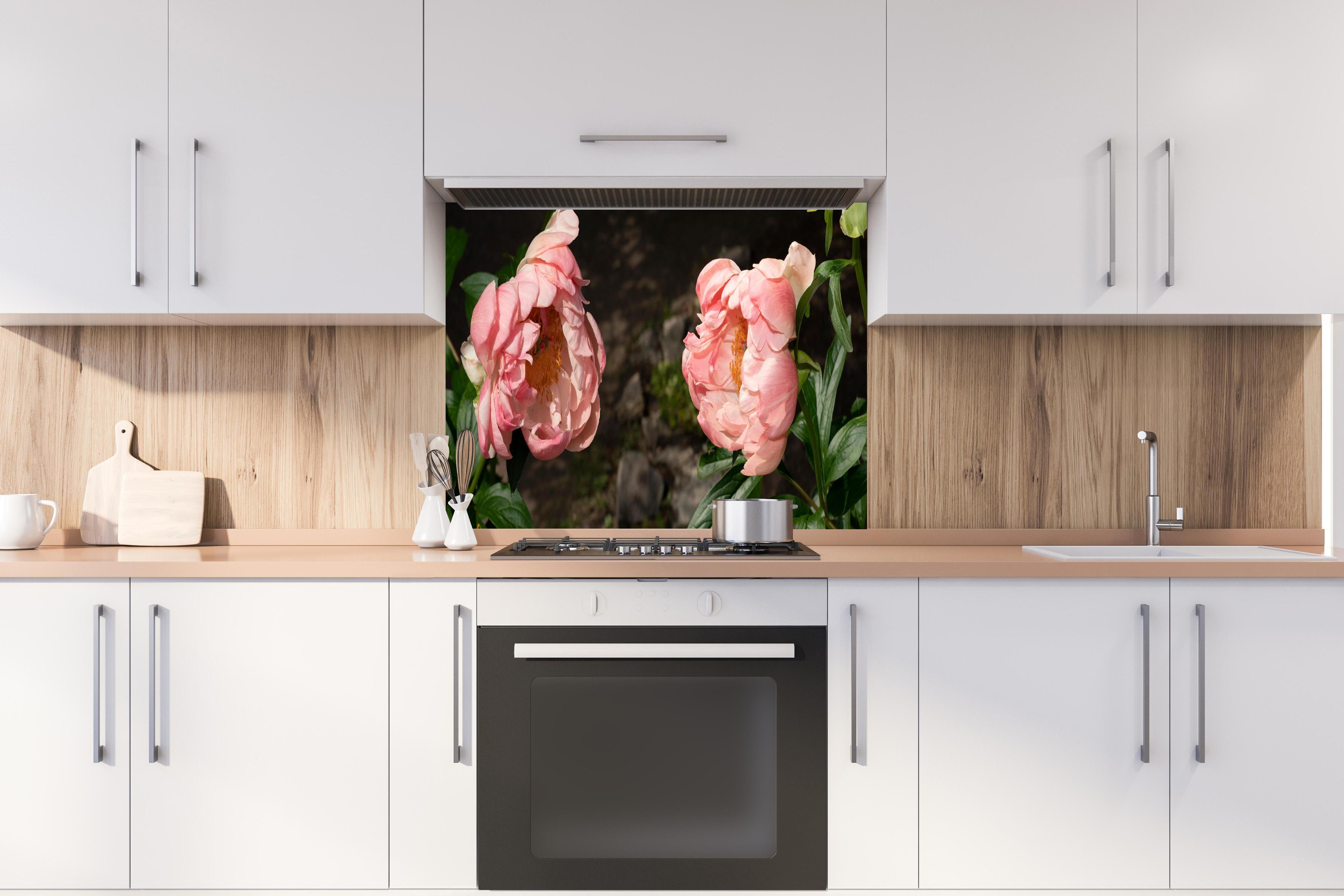 Spritzschutz - Zwei rosa Pfingstrosen in einem alten Garten. hinter einem Cerankochfeld zwischen Holz-Kochutensilien