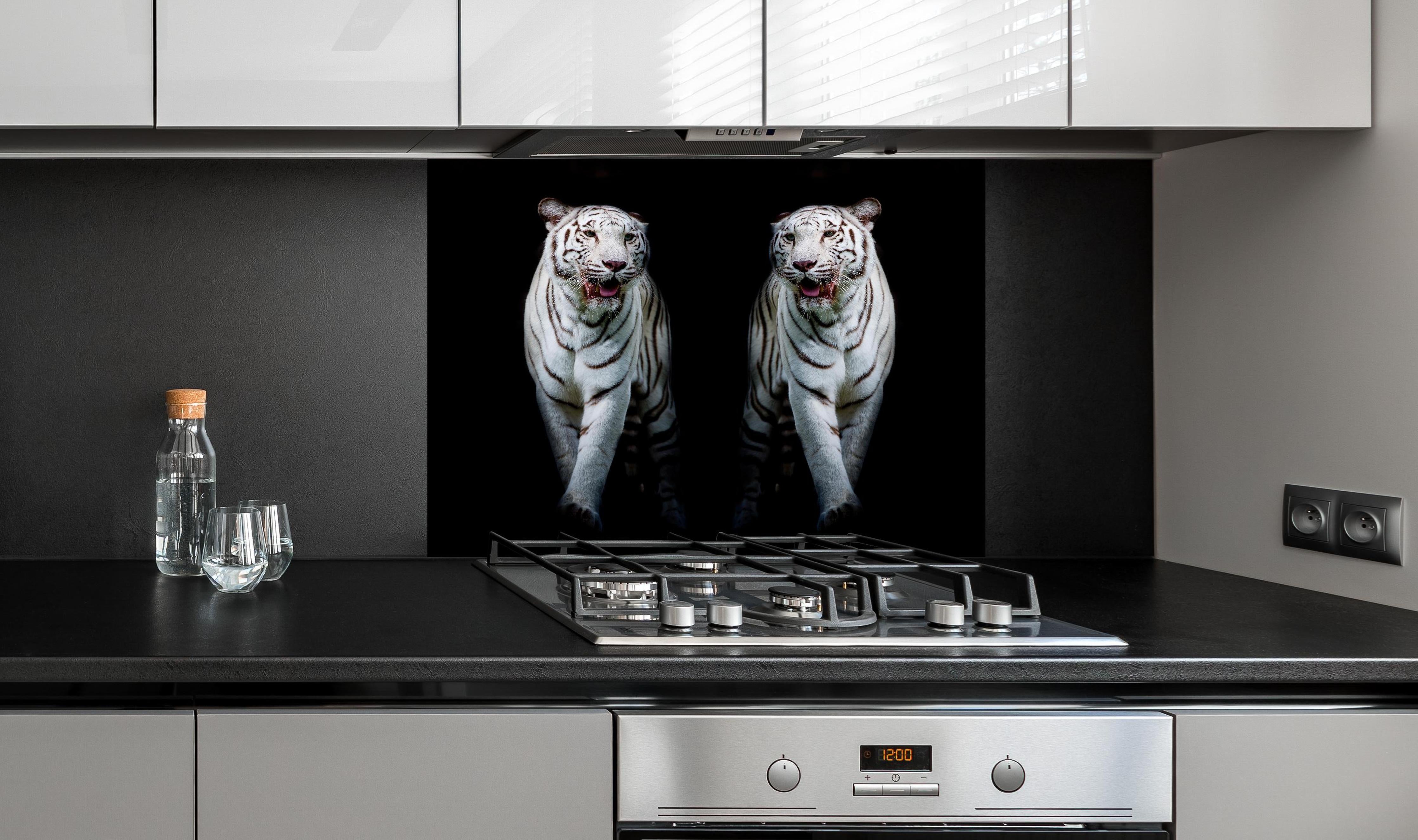 Spritzschutz - Zwei weiße Tiger auf schwarzem Hintergrund hinter einem Cerankochfeld zwischen Holz-Kochutensilien
