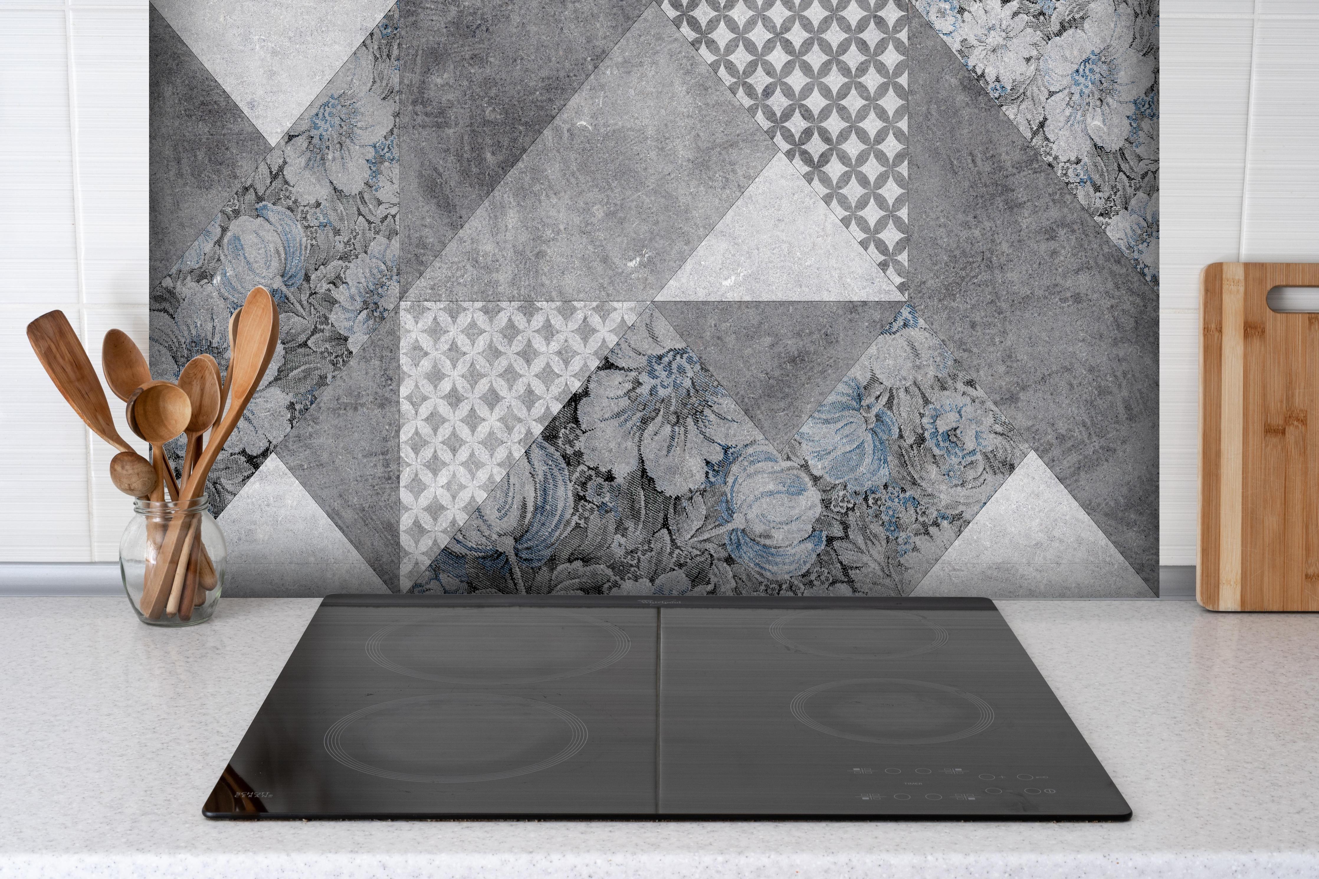 Spritzschutz - abstrakte Blumen und Marmor Textur hinter einem Cerankochfeld zwischen Holz-Kochutensilien