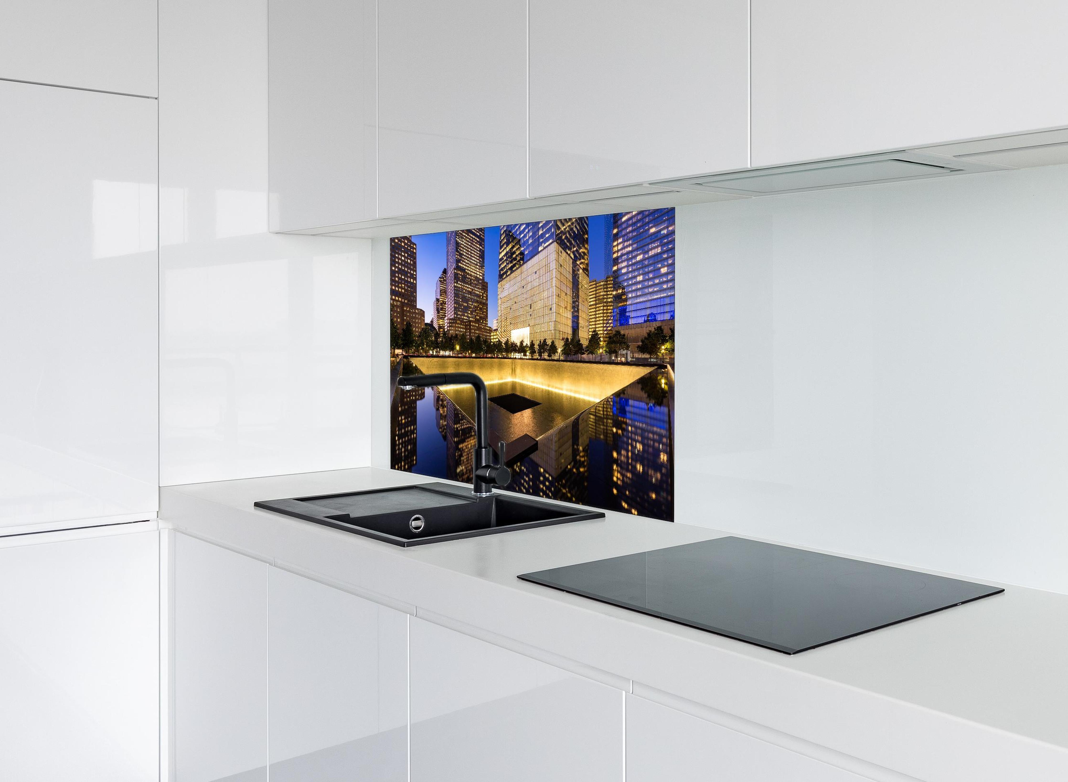 Spritzschutz - nächtlich Beleuchtetes World Trade Center Site hinter einem Cerankochfeld zwischen Holz-Kochutensilien