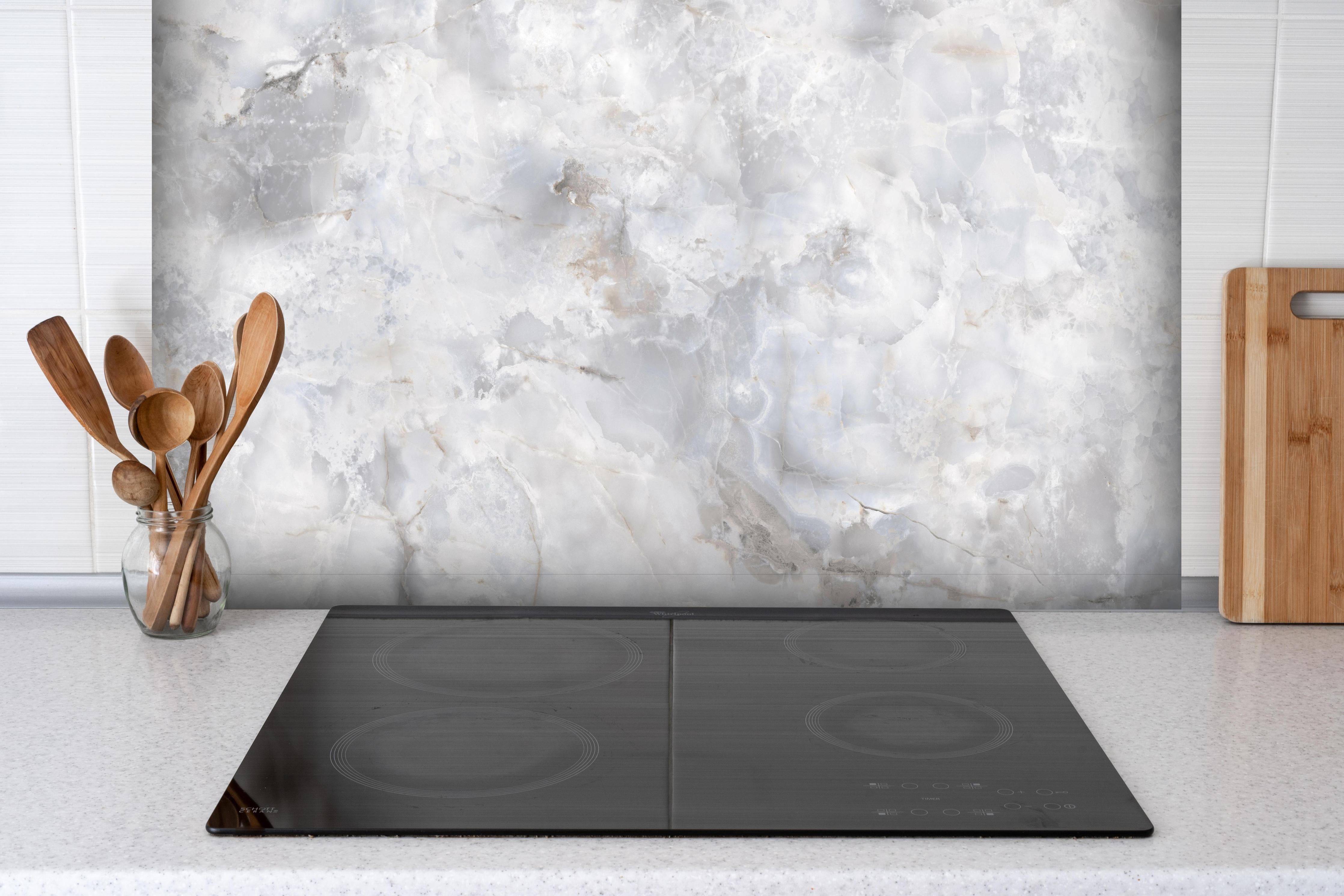 Spritzschutz - onyx marmor textur hinter einem Cerankochfeld zwischen Holz-Kochutensilien