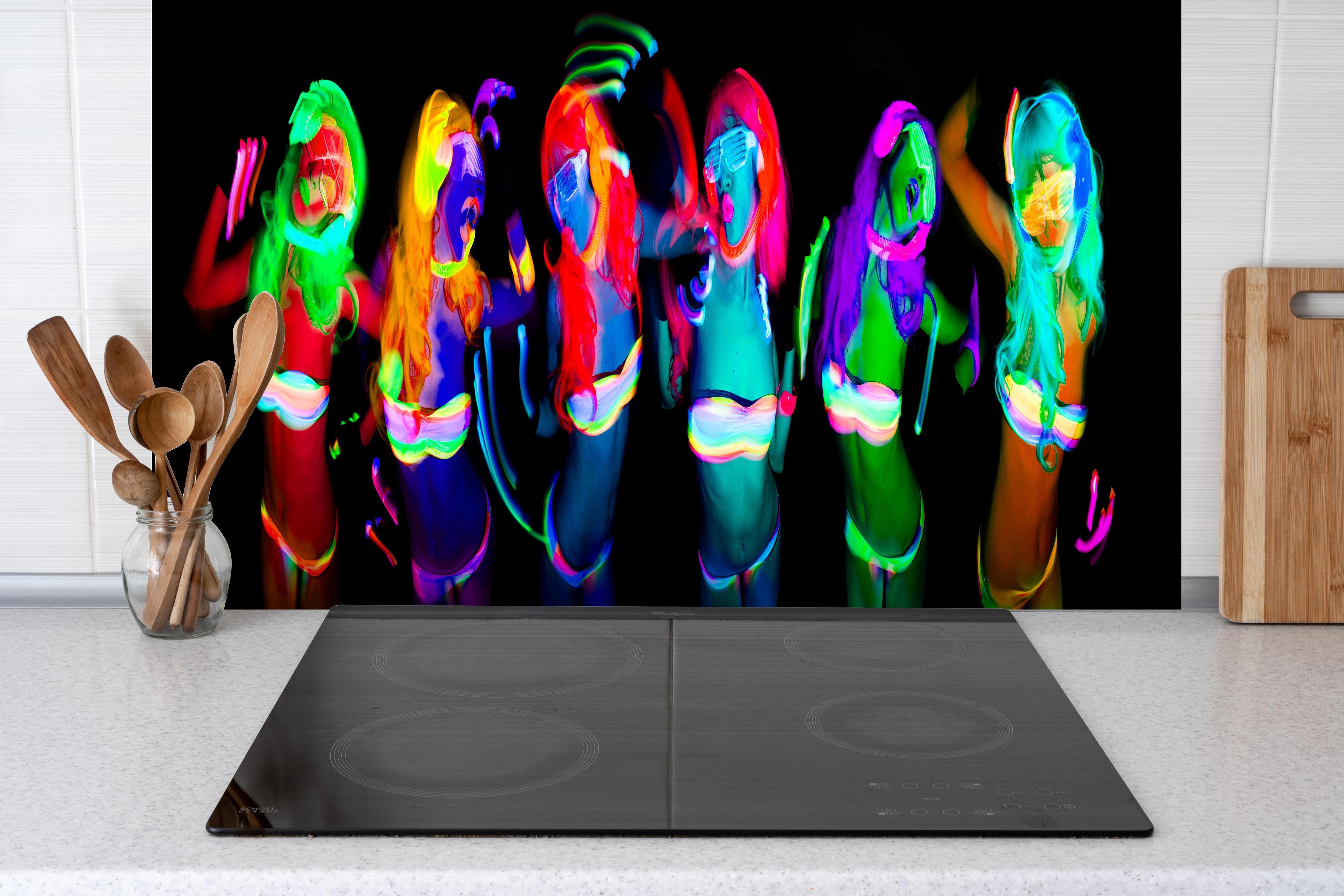 Spritzschutz - sexy neon uv glow tänzerin hinter einem Cerankochfeld zwischen Holz-Kochutensilien