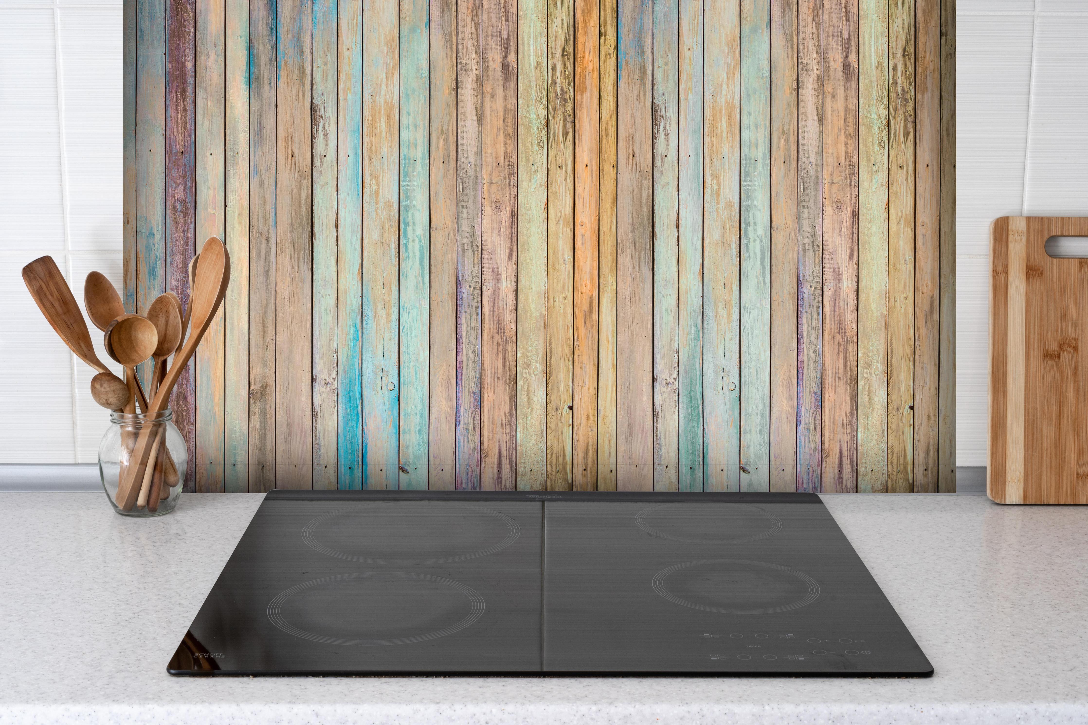 Spritzschutz - vielfarbiger Hintergrund - alte Holzplanken hinter einem Cerankochfeld zwischen Holz-Kochutensilien