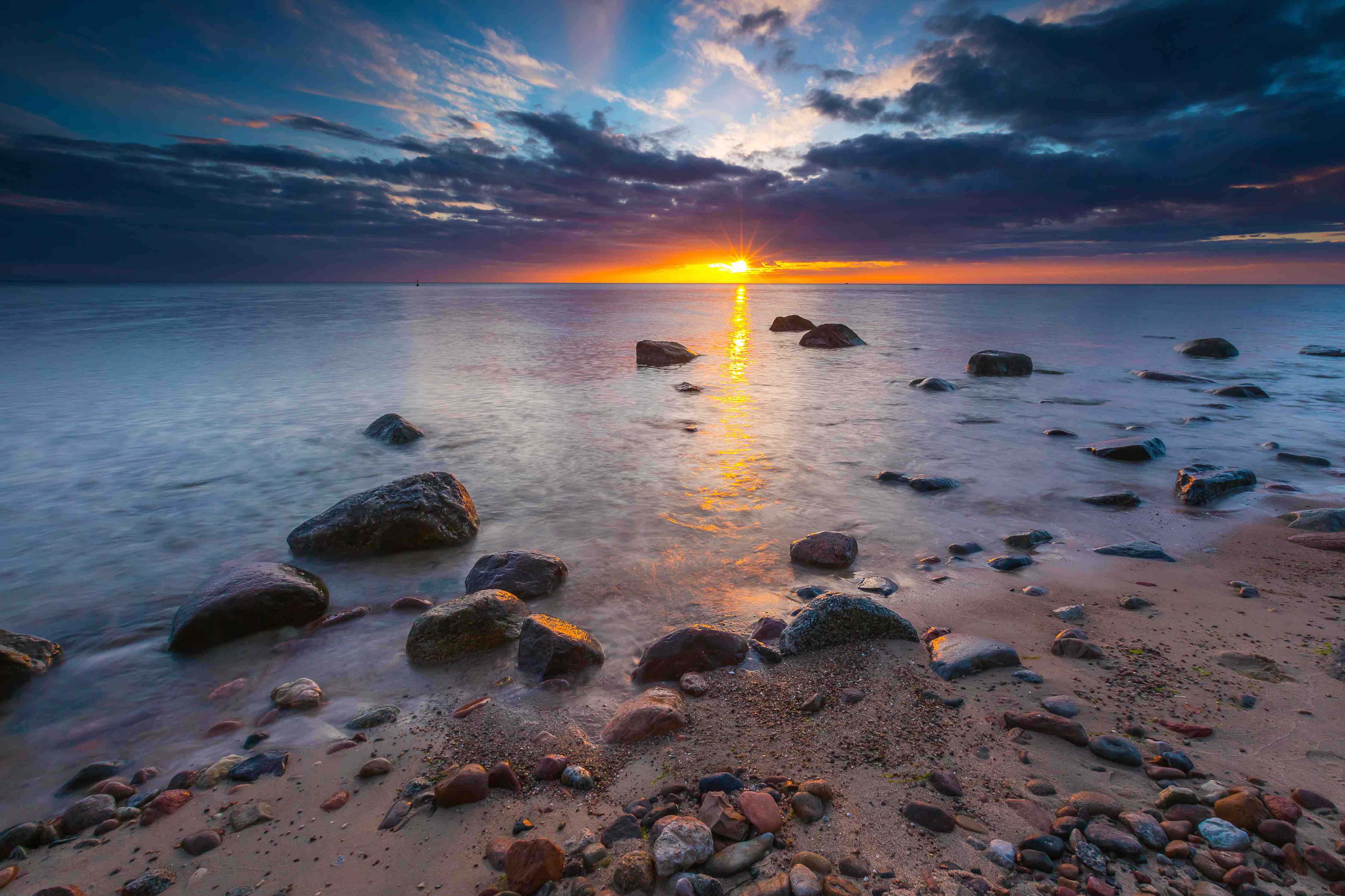 Wandverkleidung Bad-Sonnenuntergang am Strand mit Steinen und Wolken