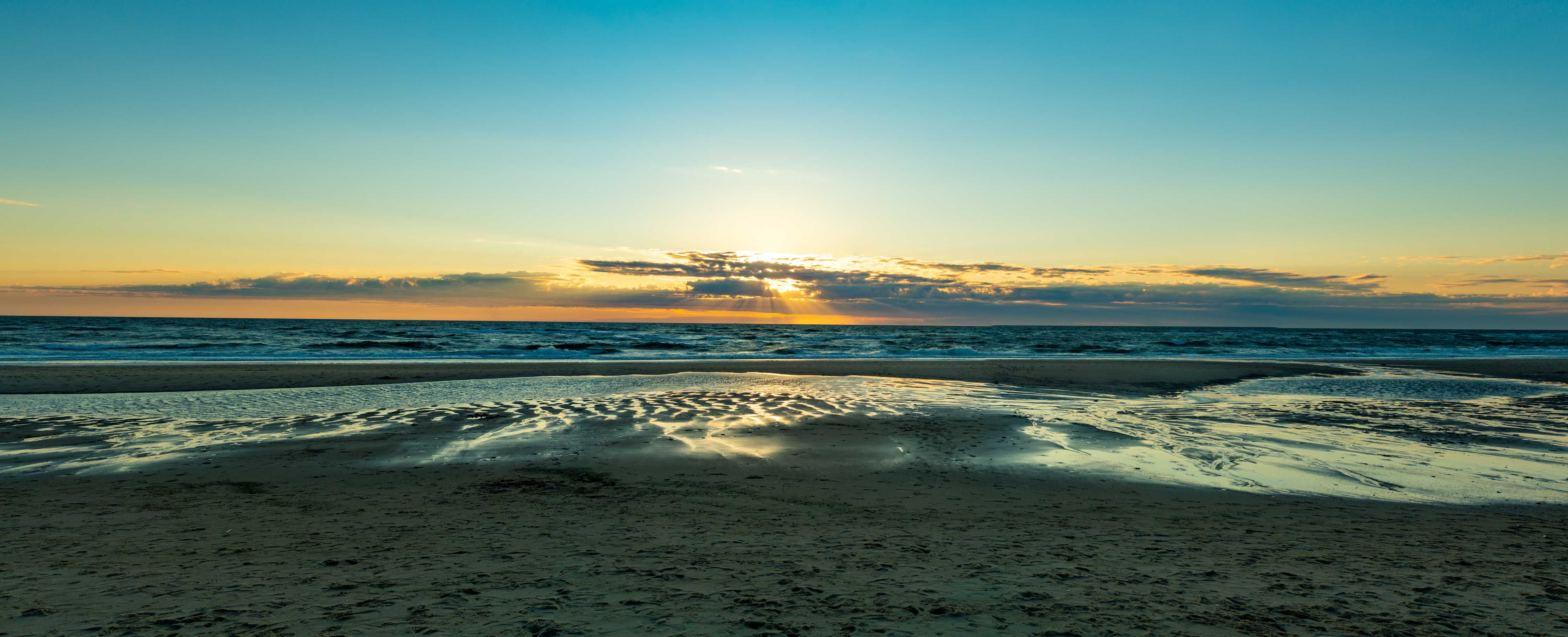 Wandverkleidung Bad-Sonnenuntergang am Strand mit glitzerndem Wasser und ruhiger Atmosphäre