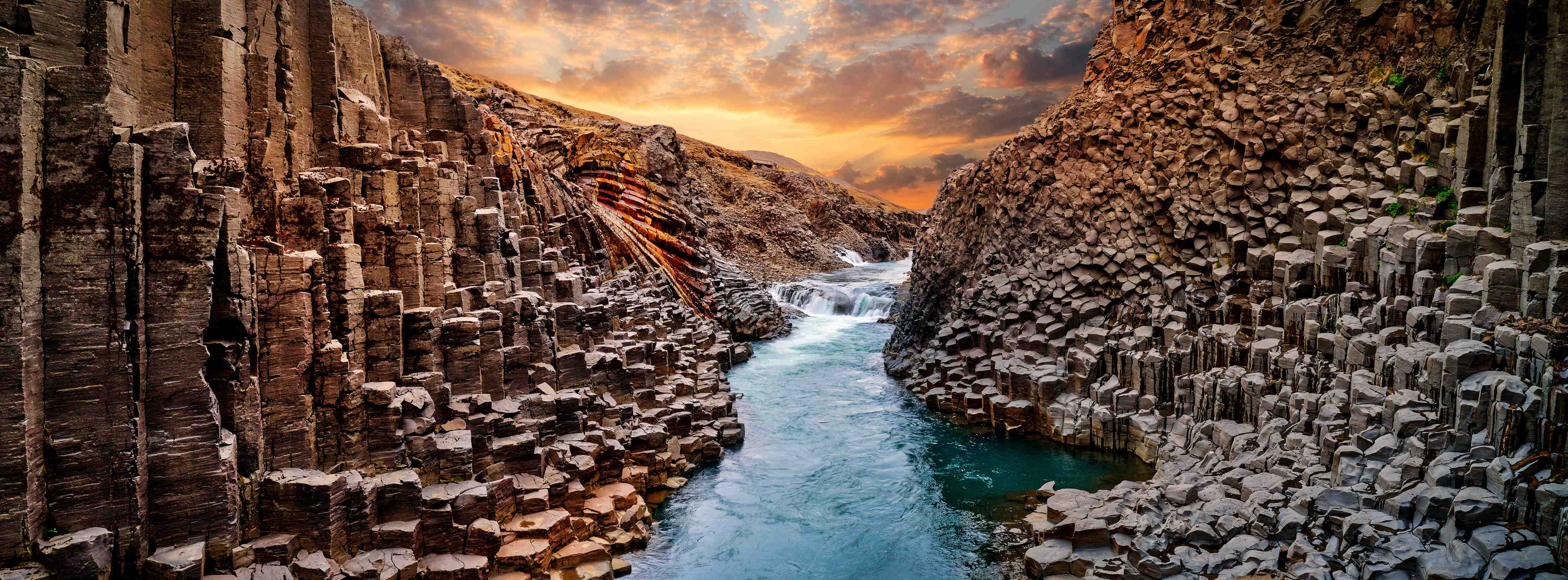 Wandverkleidung Flur-Naturfotografie: Bunter Fluss in Felslandschaft
