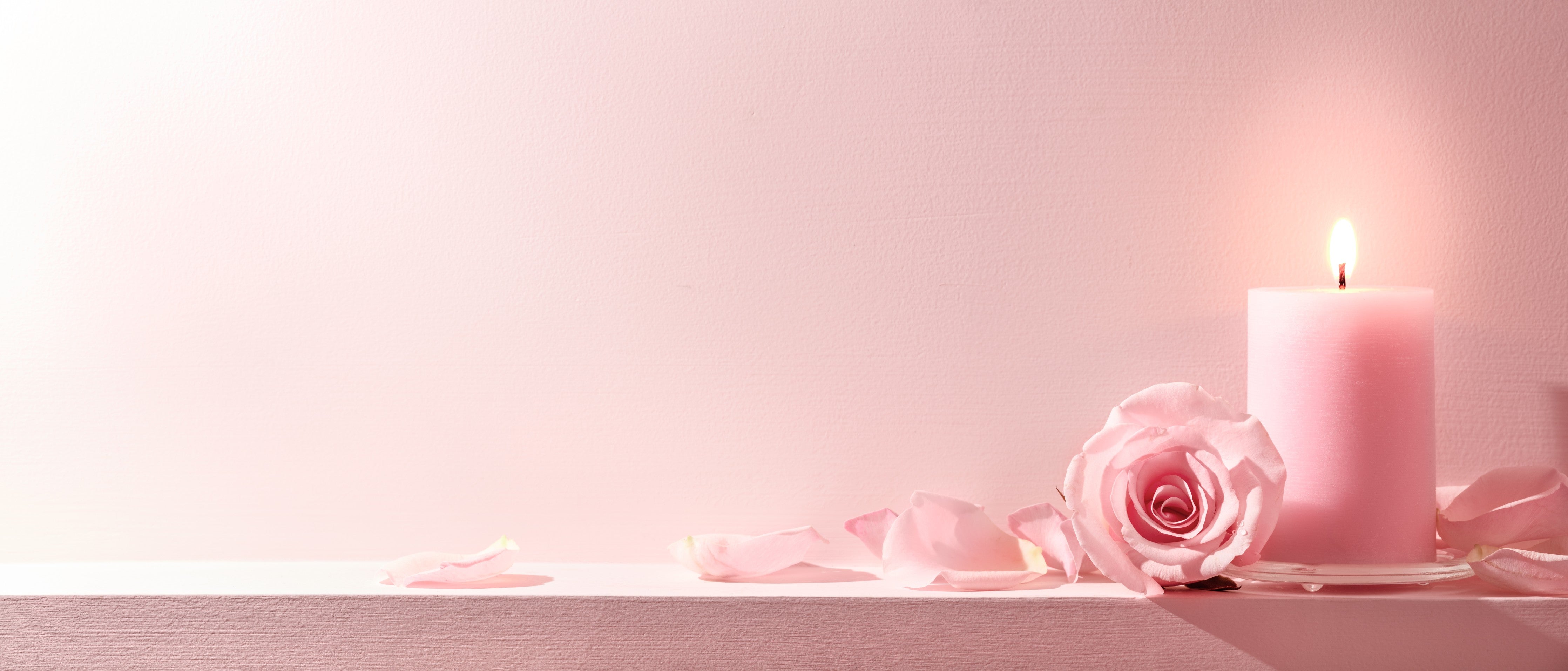 Wandverkleidung Schlafzimmer-Rosa Rosen und Kerze auf einem rosa Hintergrund