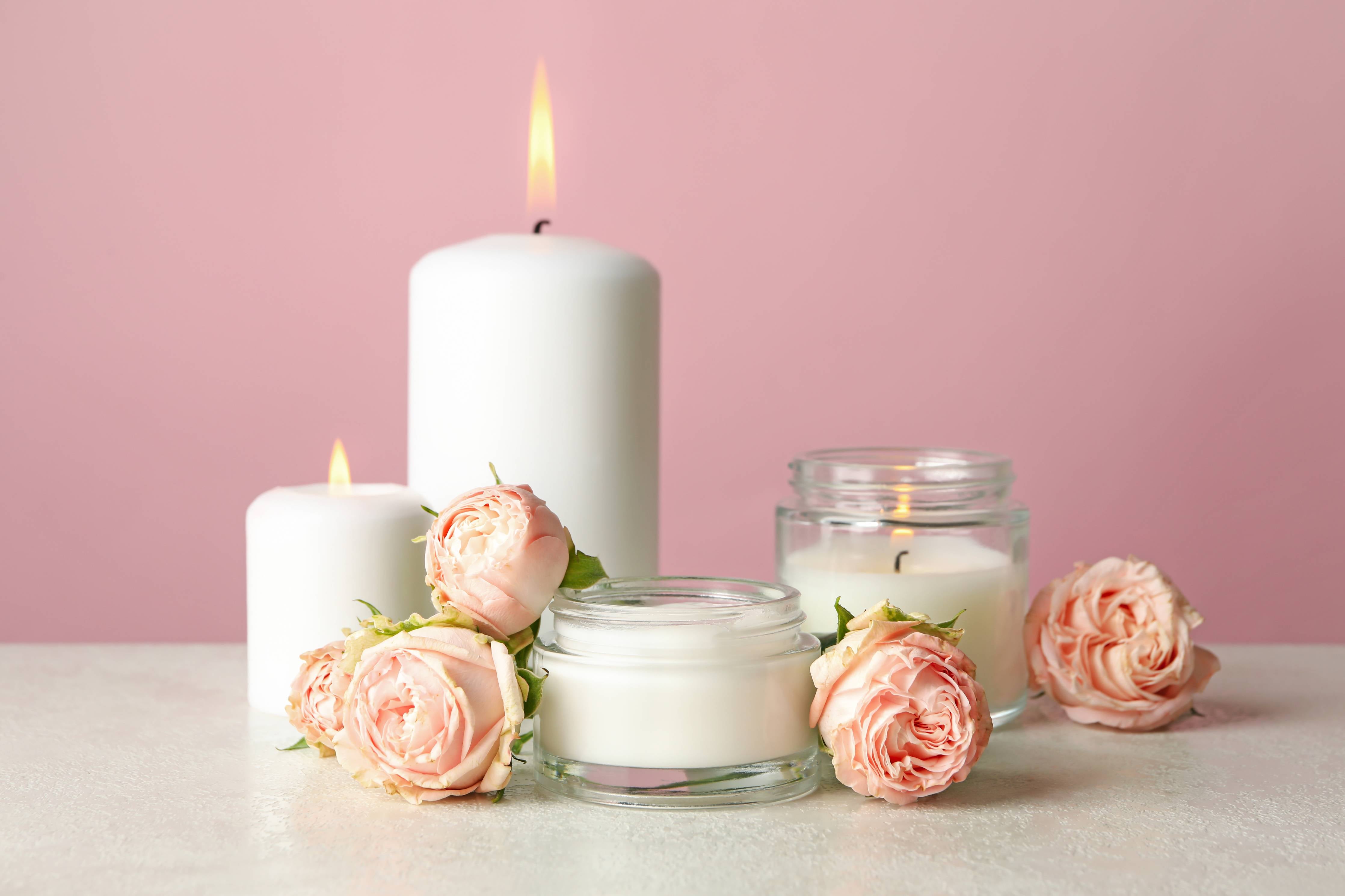 Wandverkleidung außen-Duftkerzen und Rosen auf weißem Tisch
