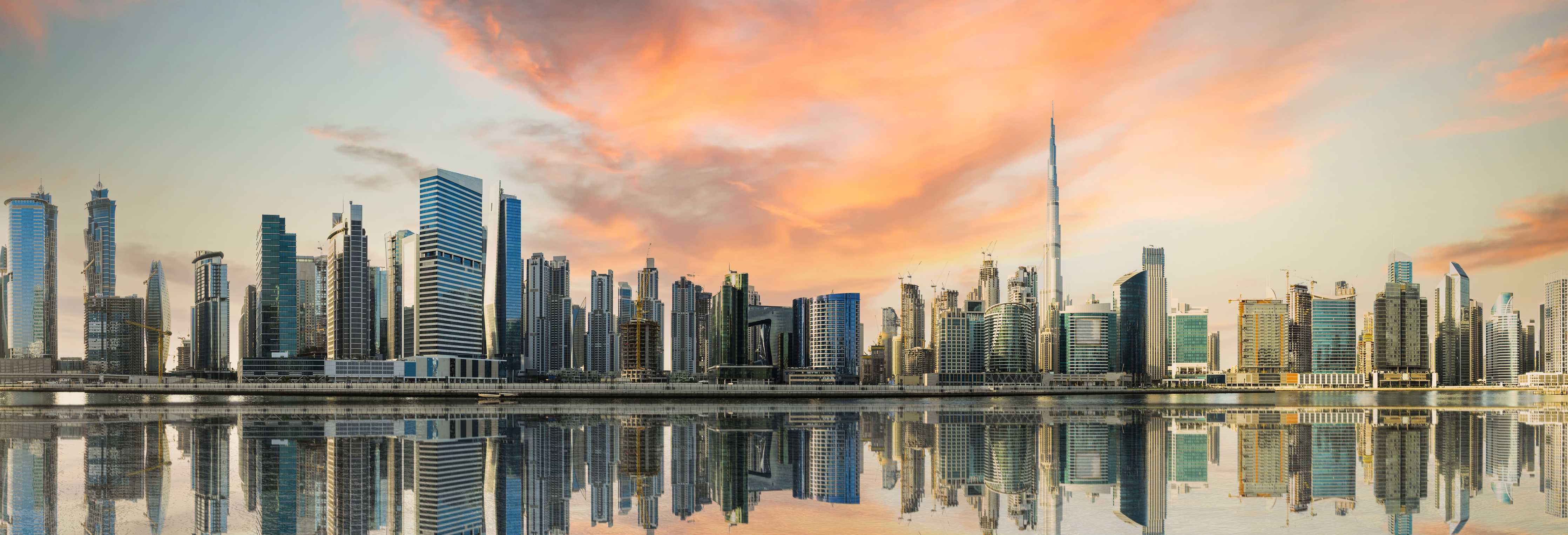 Wandverkleidung außen-Moderne Skyline bei Sonnenuntergang mit reflektierendem Wasser