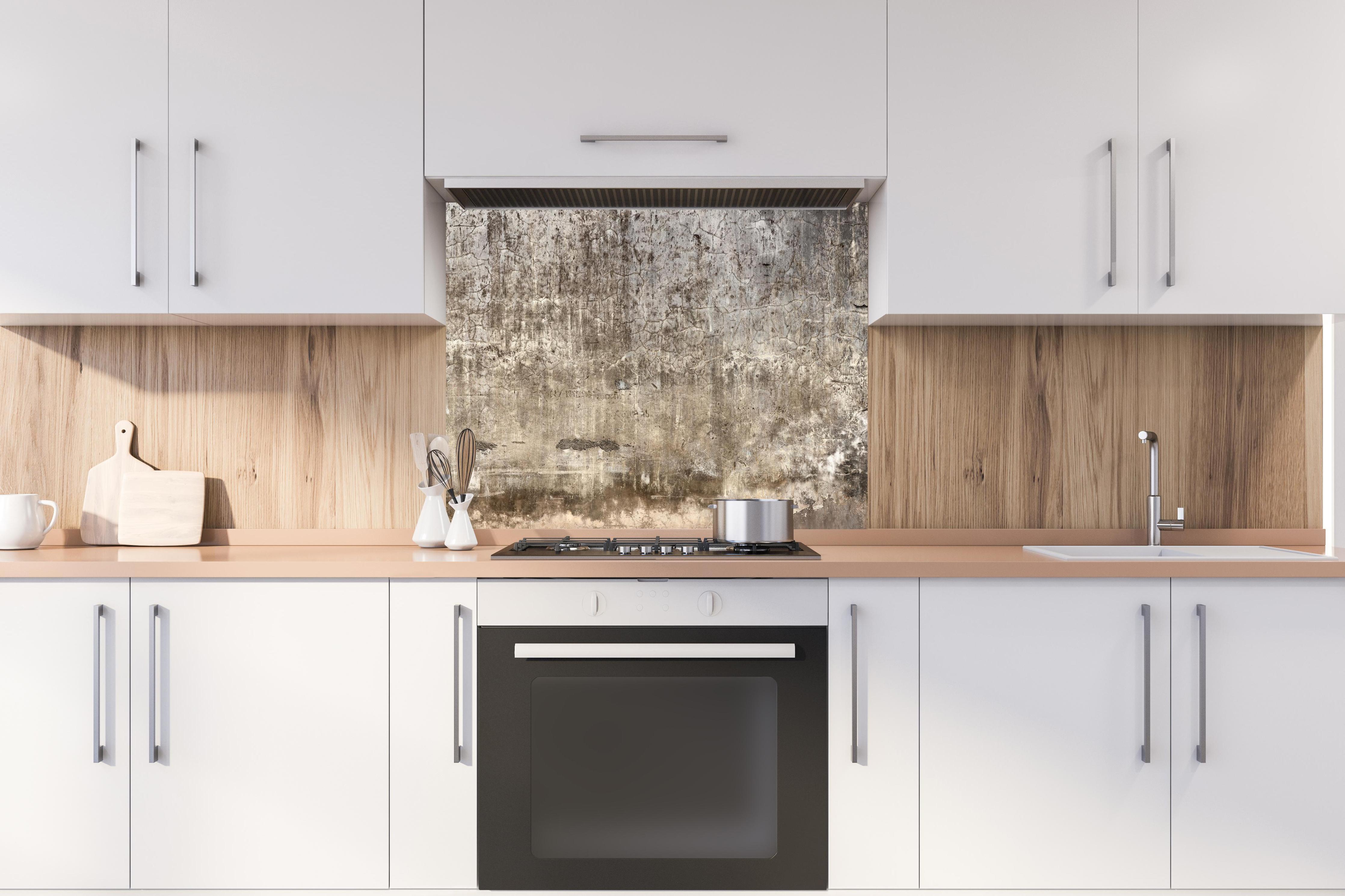 Spritzschutz - Spritzschutz - Schmutzige Wand mit bröckelndem Zementputz hinter stilvollem Gasherd unter Dunstabzugshaube