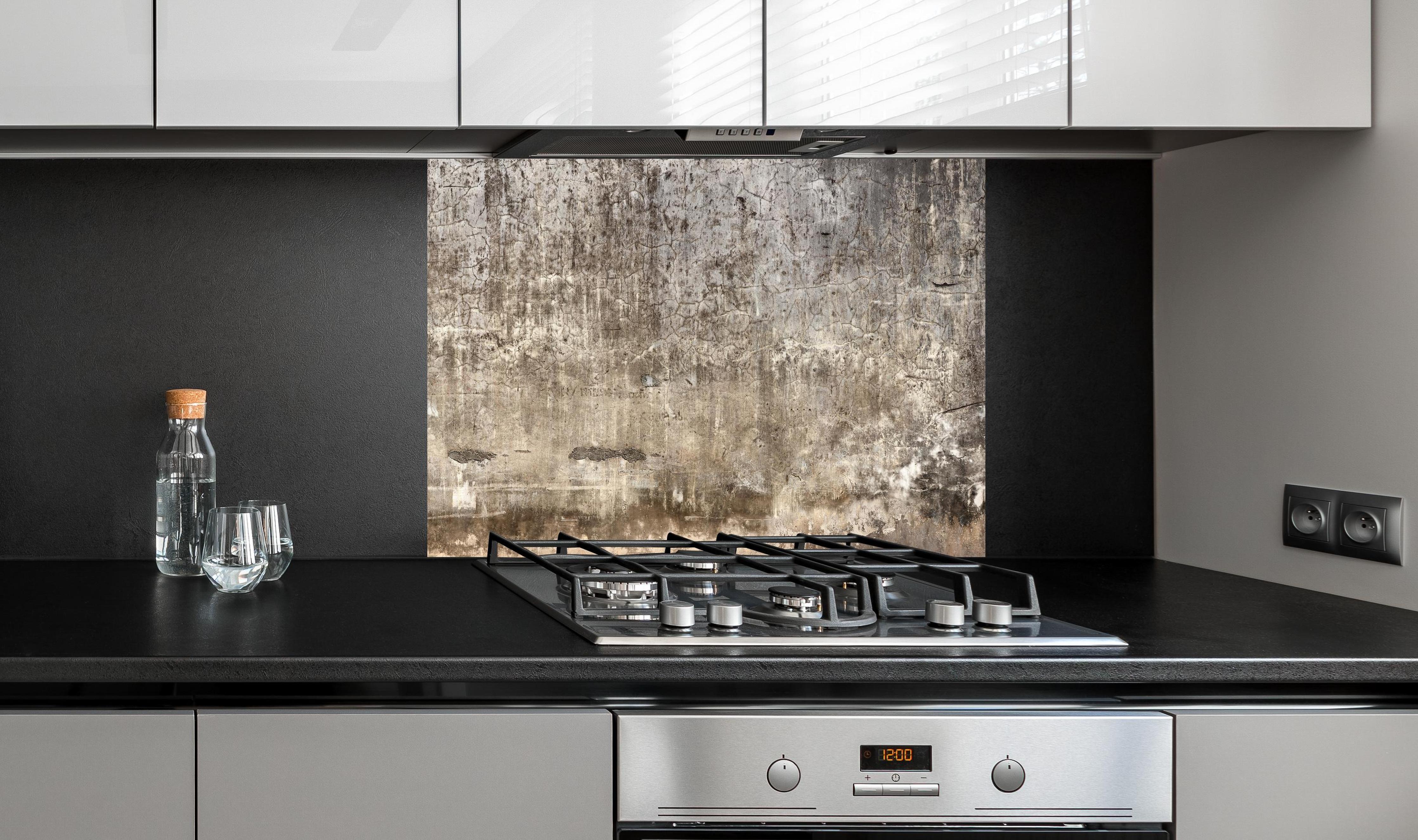 Spritzschutz - Spritzschutz - Schmutzige Wand mit bröckelndem Zementputz an edler Anthrazit-Wand hinter silbernem Gasherd