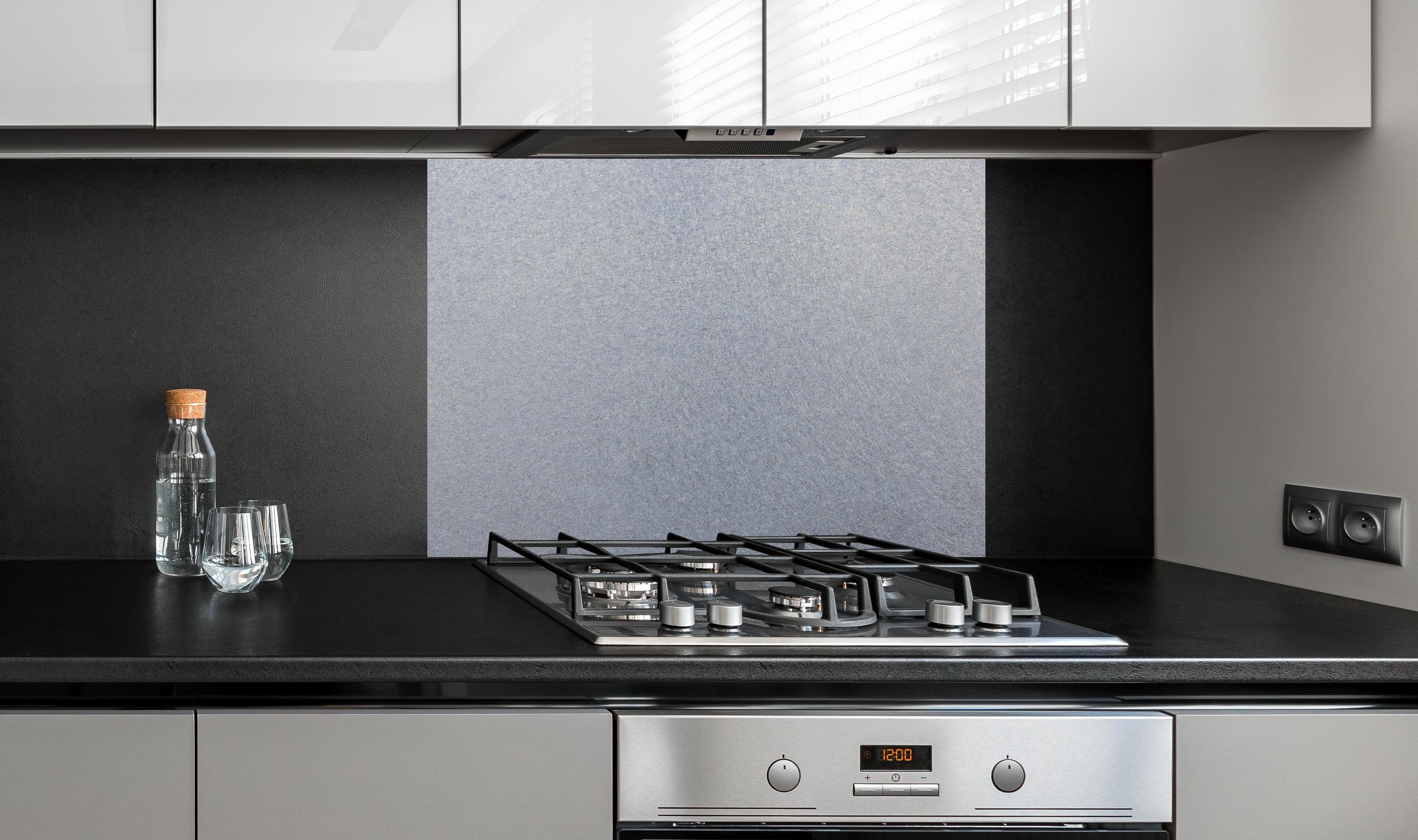 Spritzschutz - Spritzschutz - Zerkratzte metallische Oberfläche an edler Anthrazit-Wand hinter silbernem Gasherd