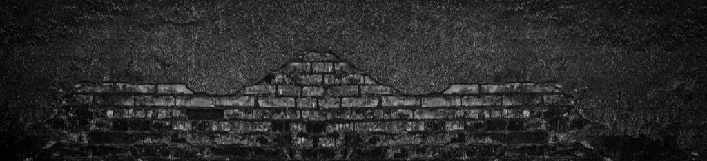 Küchenrückwand - Schwarz gebrannte Ziegelwand mit abgefallenem Putz