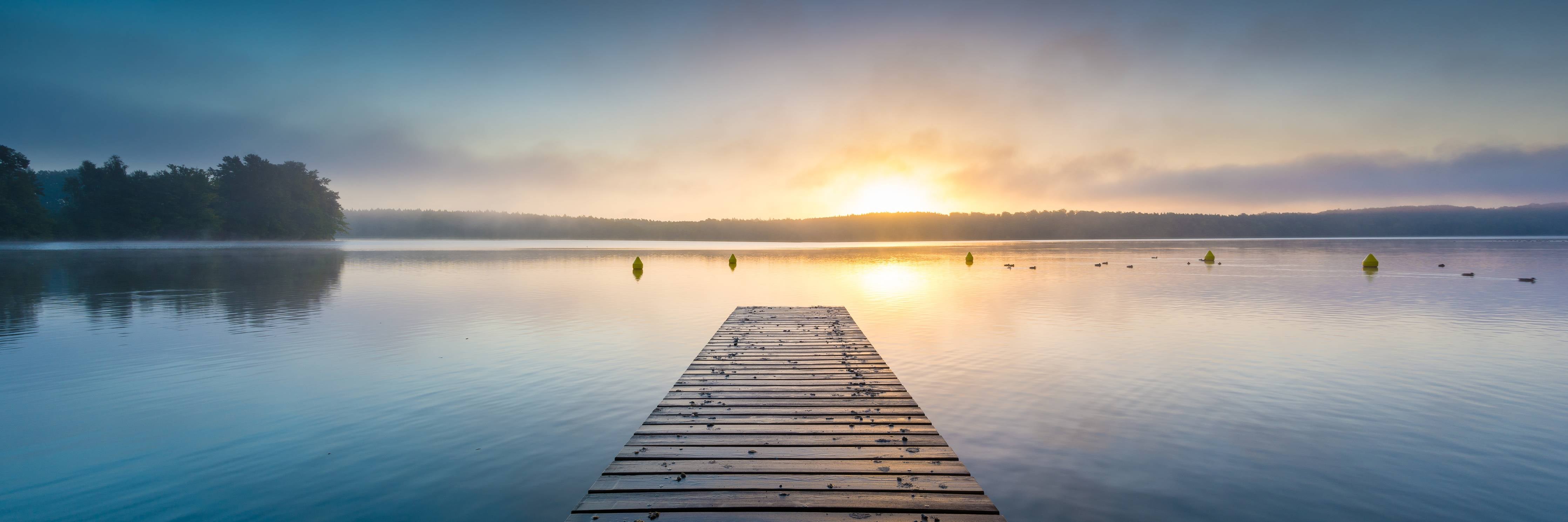 Badewannen-Rückwand-Sonnenaufgang am See mit Nebel