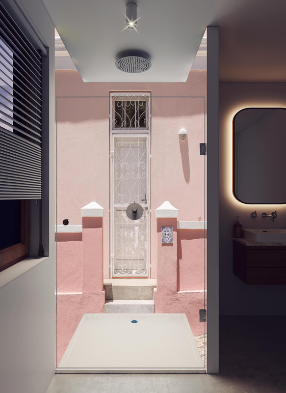 Duschrückwand - Charmante pastellrosa Hausfassade in hellem Badezimmer mit Regenduschkopf  - zweiteilige Eck-Duschrückwand