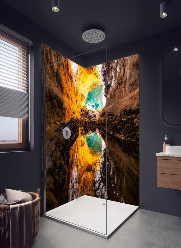 Duschrückwand - Bunte Lavaröhre in Spanien in dunklem Badezimmer mit Regenduschkopf