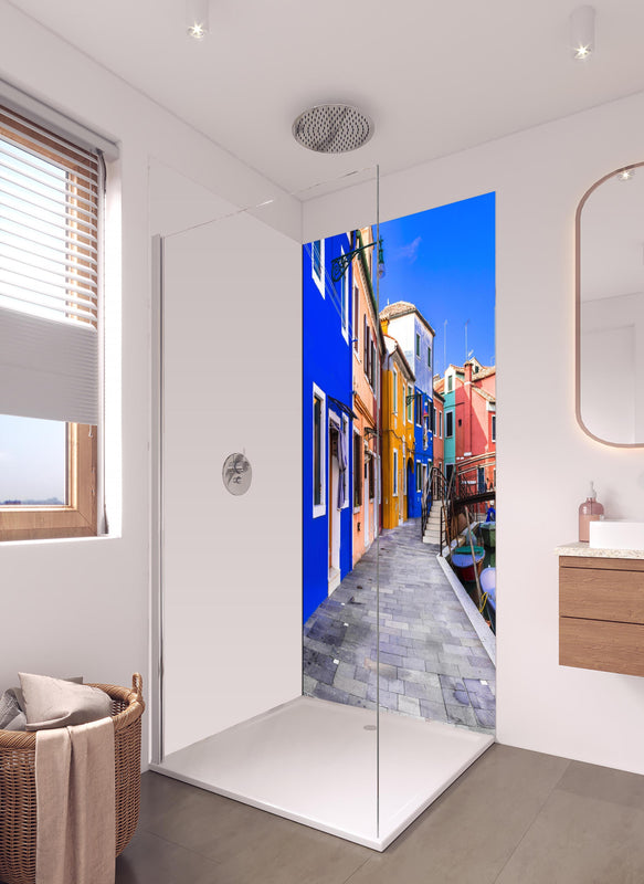 Duschrückwand - Die farbenfrohe Insel Burano in hellem Badezimmer mit Regenduschkopf - einteilige Duschrückwand
